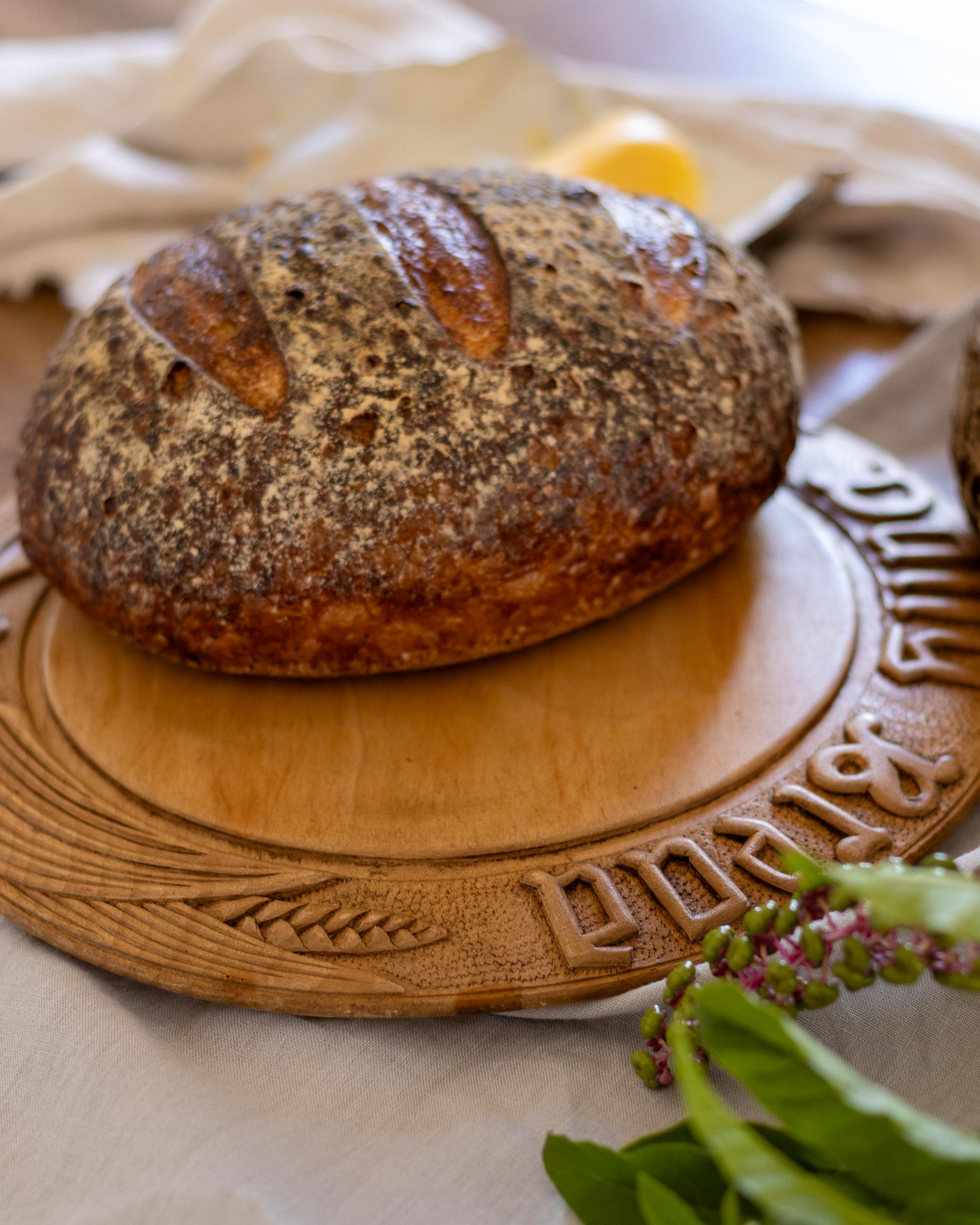 Loaf of bread on an antique wooden board with decorative carvings