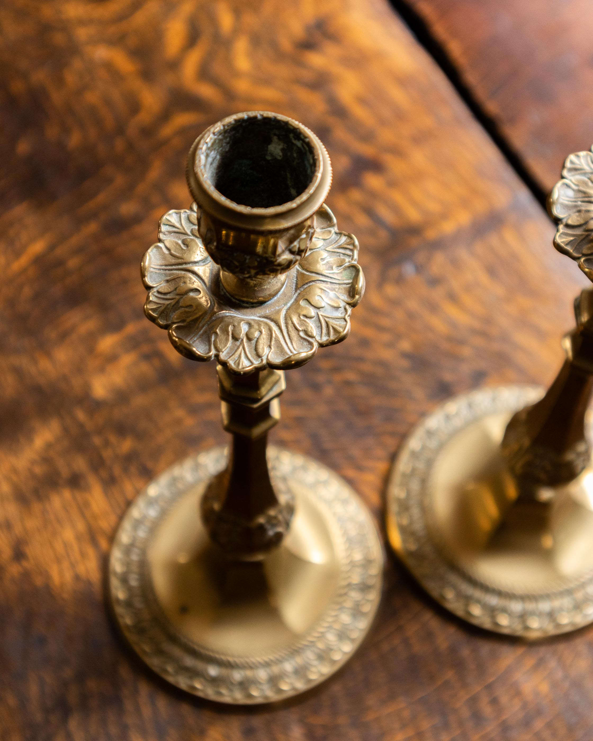 Decorative brass candlestick holders on a wooden surface