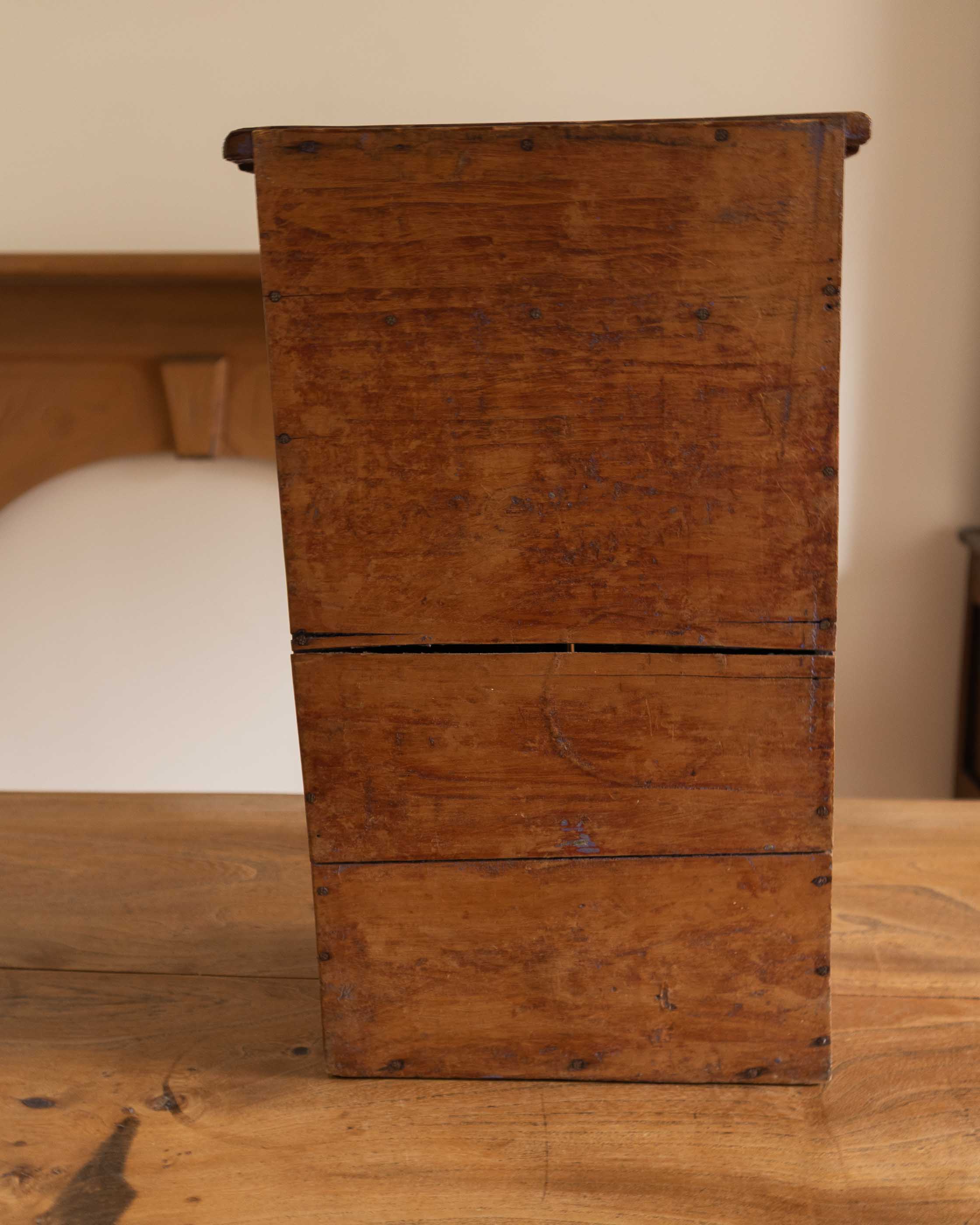 Wooden cabinet with two drawers on a wooden surface.