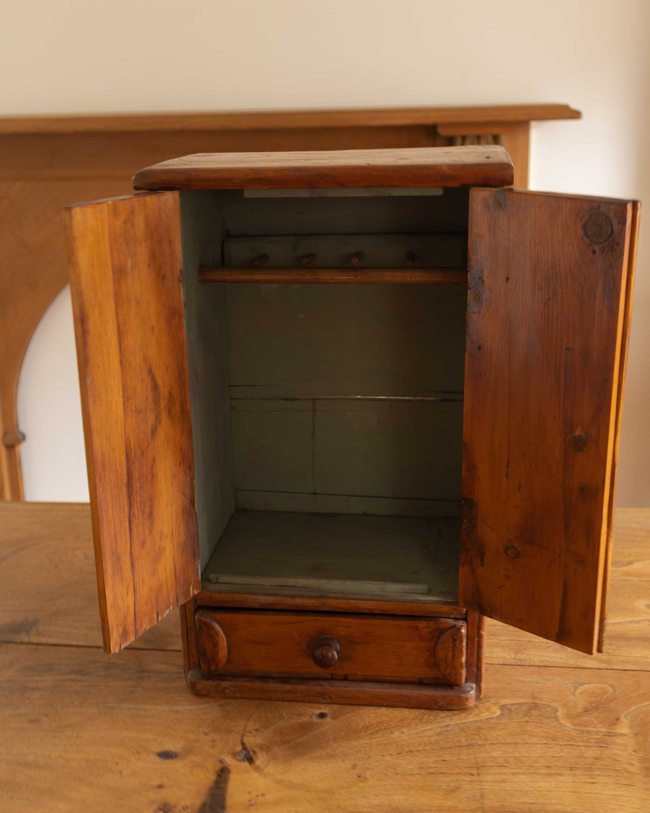 Wooden cabinet with open doors on a wooden surface