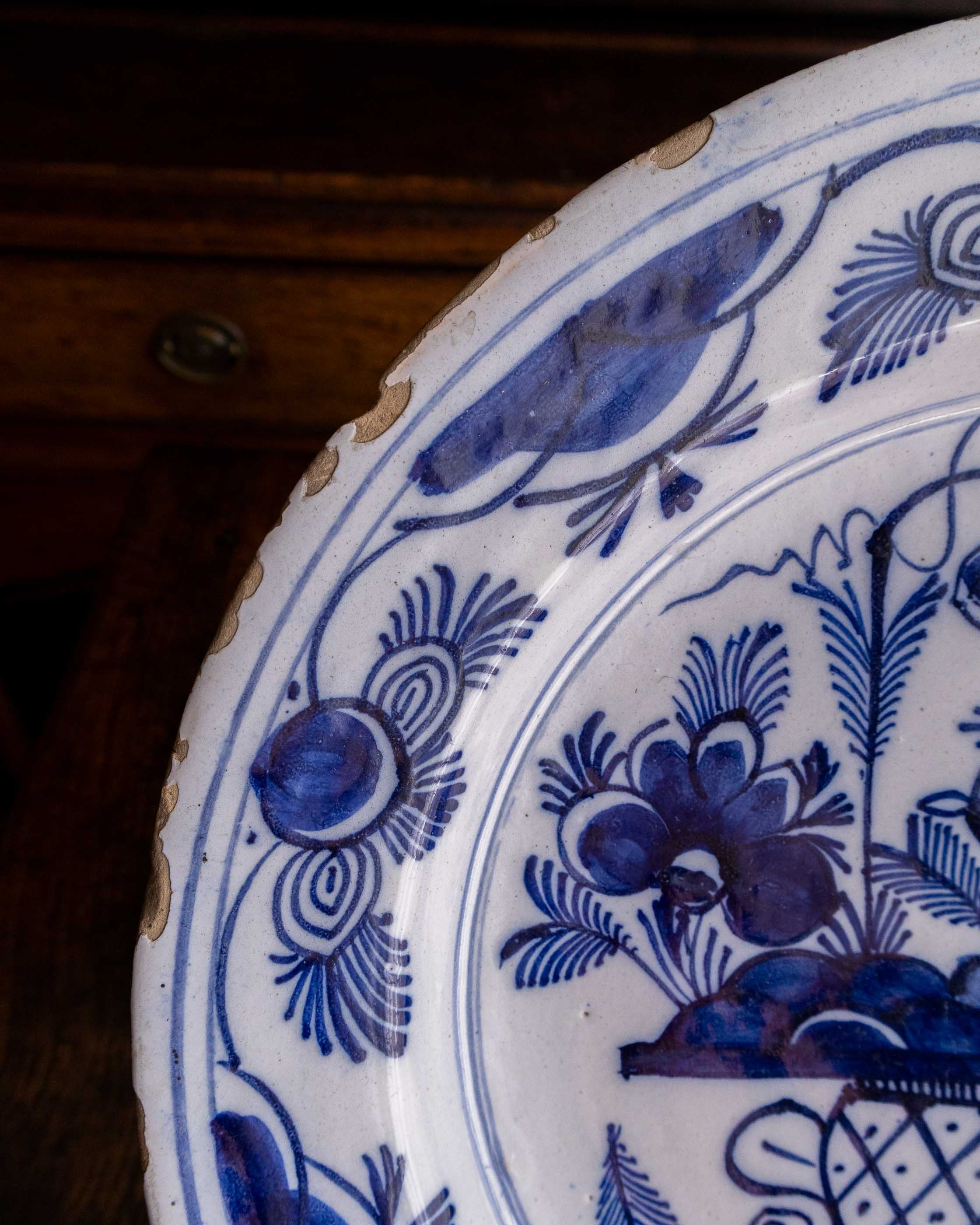Close-up of a blue and white ceramic plate with floral patterns on a wooden surface.