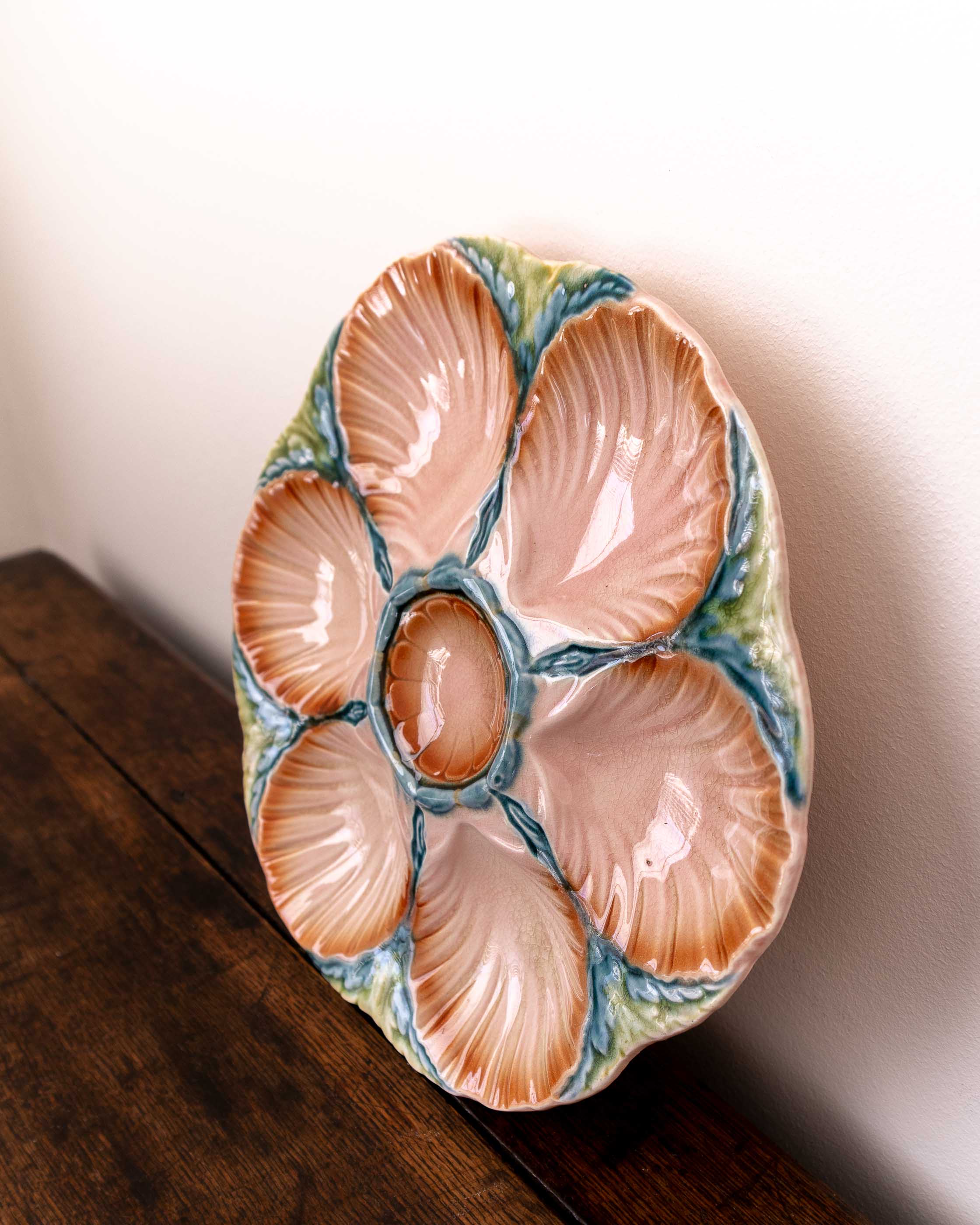 Ceramic oyster shell plate with scallop shells on a wooden surface