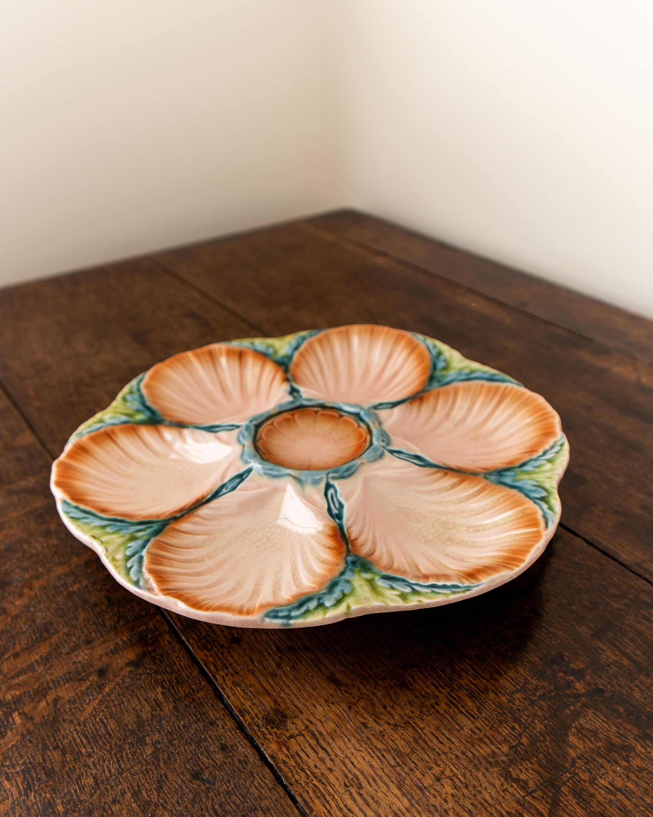 Ceramic oyster plate with shell design on a wooden surface