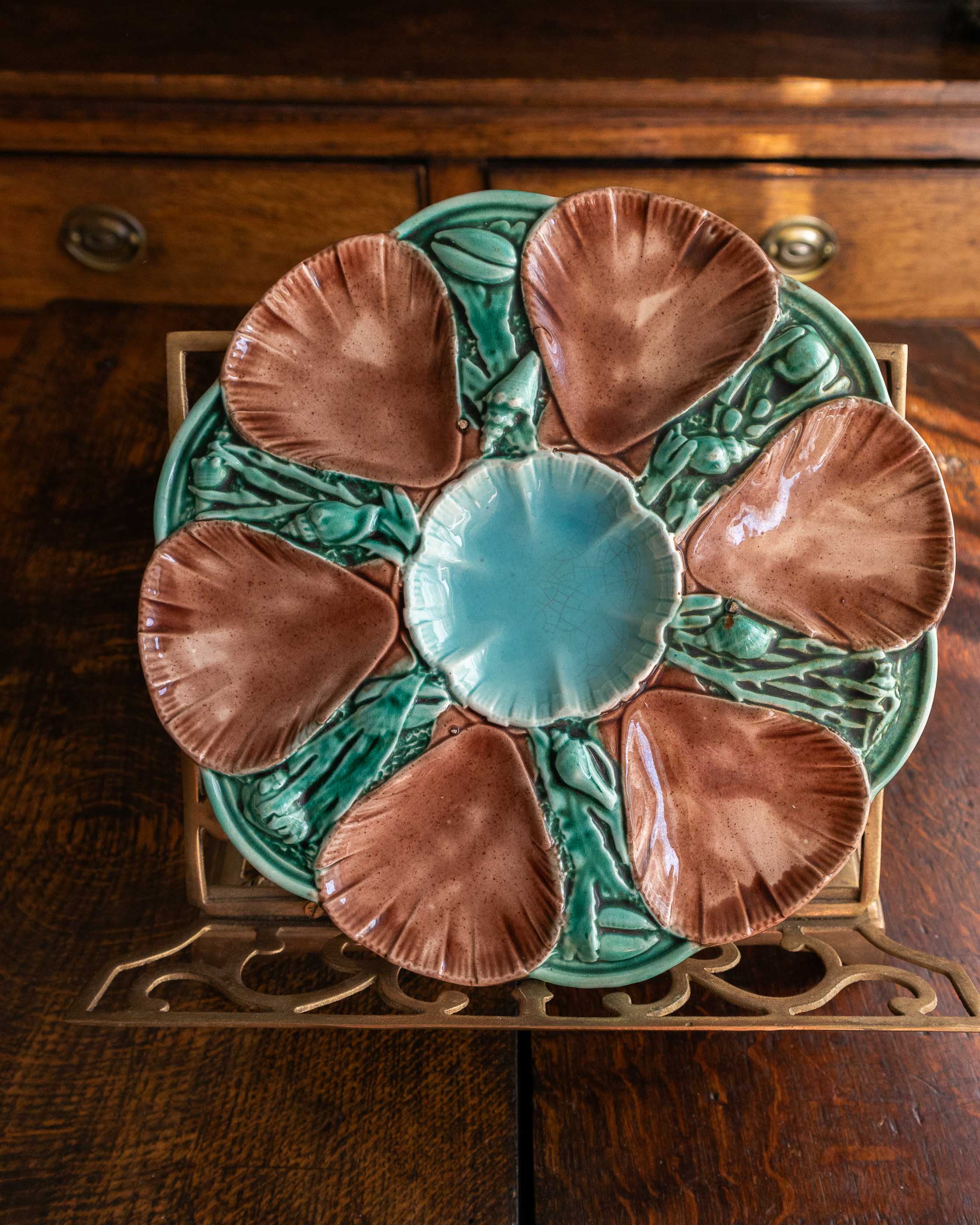 Decorative ceramic oyster plate with shell design on a wooden surface