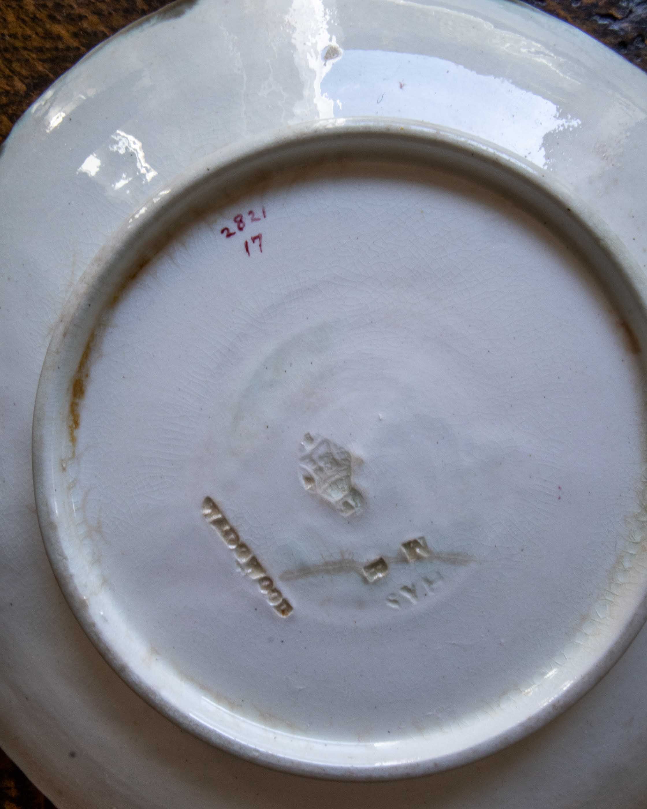 Ceramic plate with visible branding and numbers on a wooden surface