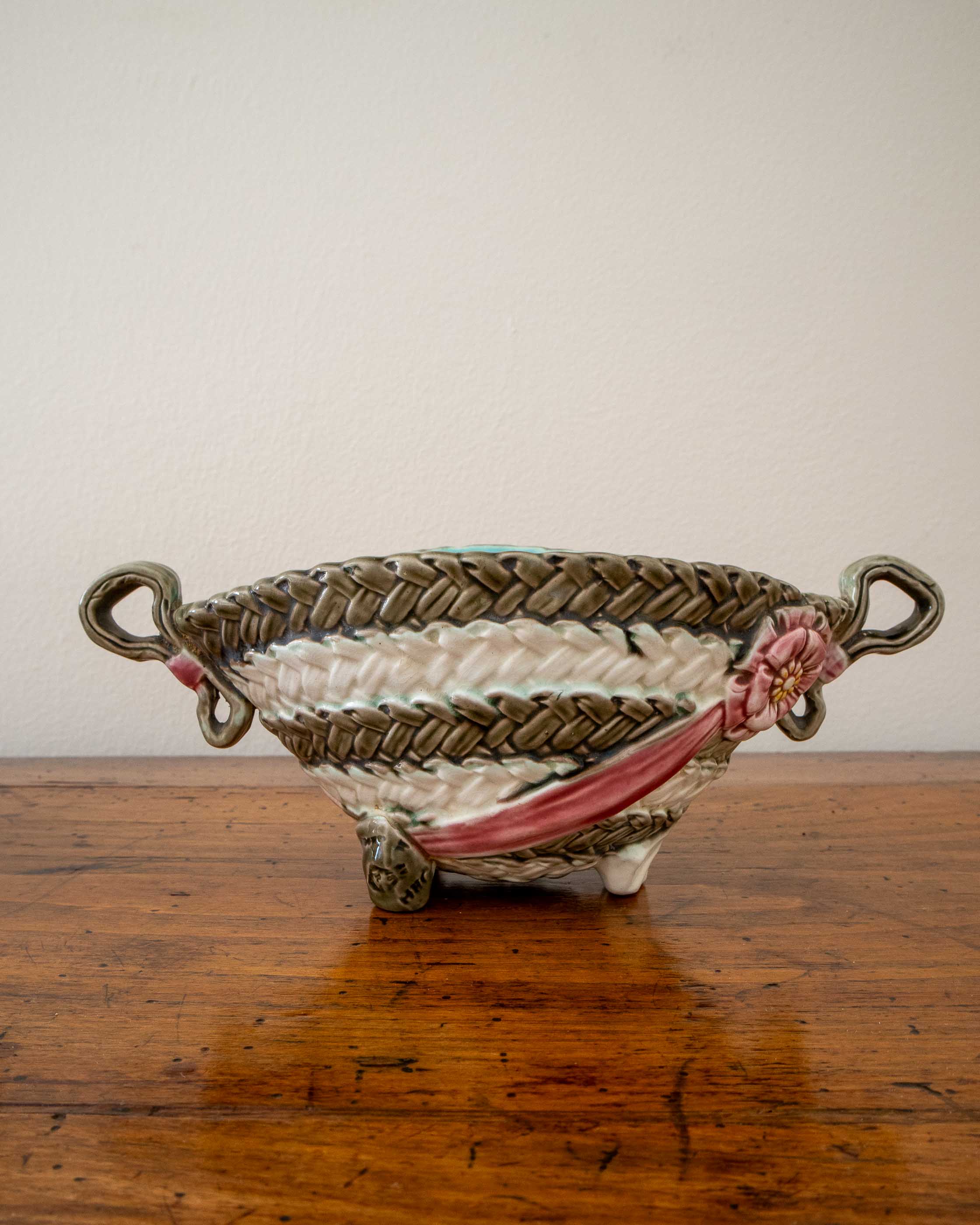 Ceramic woven basket with floral design on a wooden surface