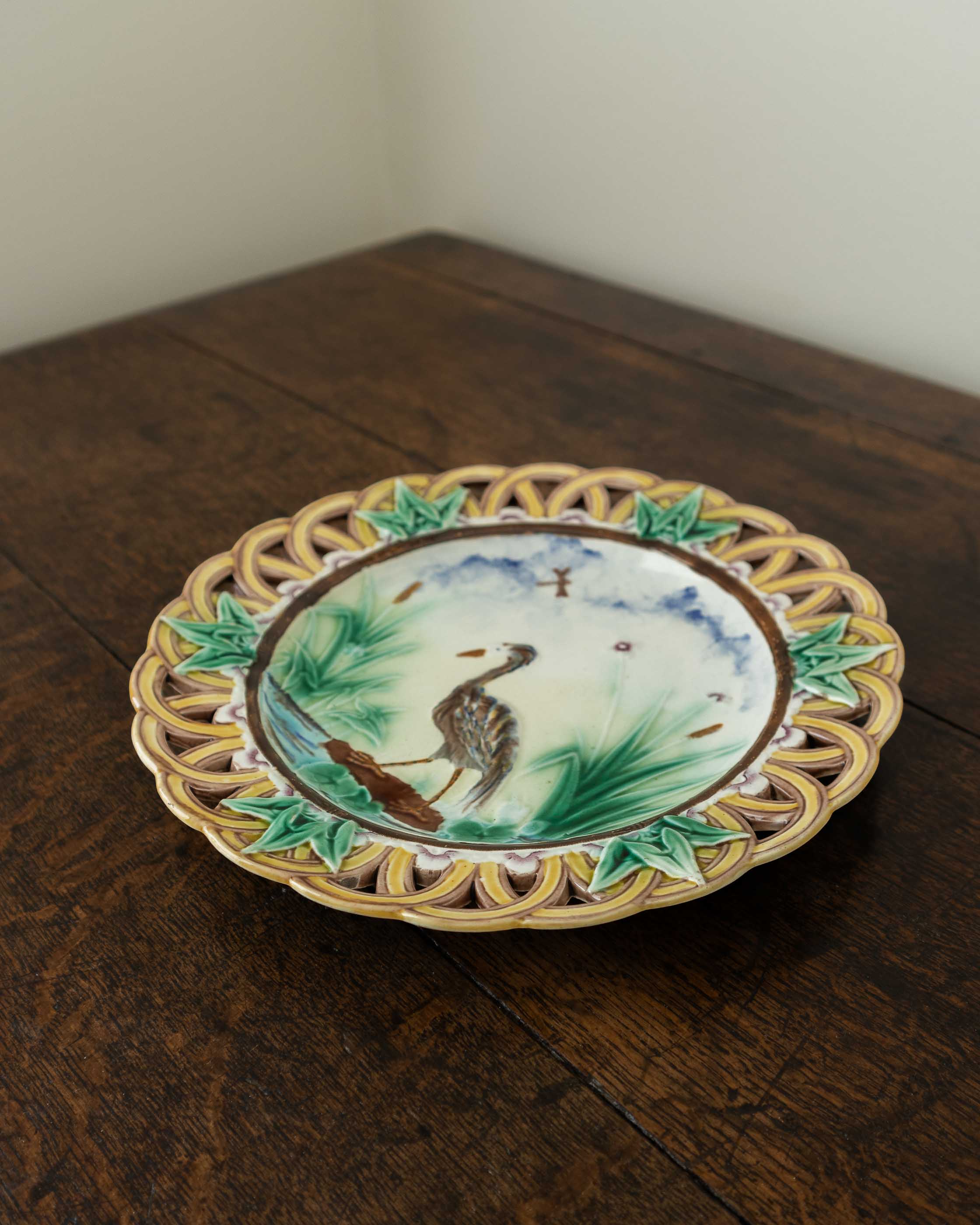 Decorative ceramic plate with bird design on a wooden surface
