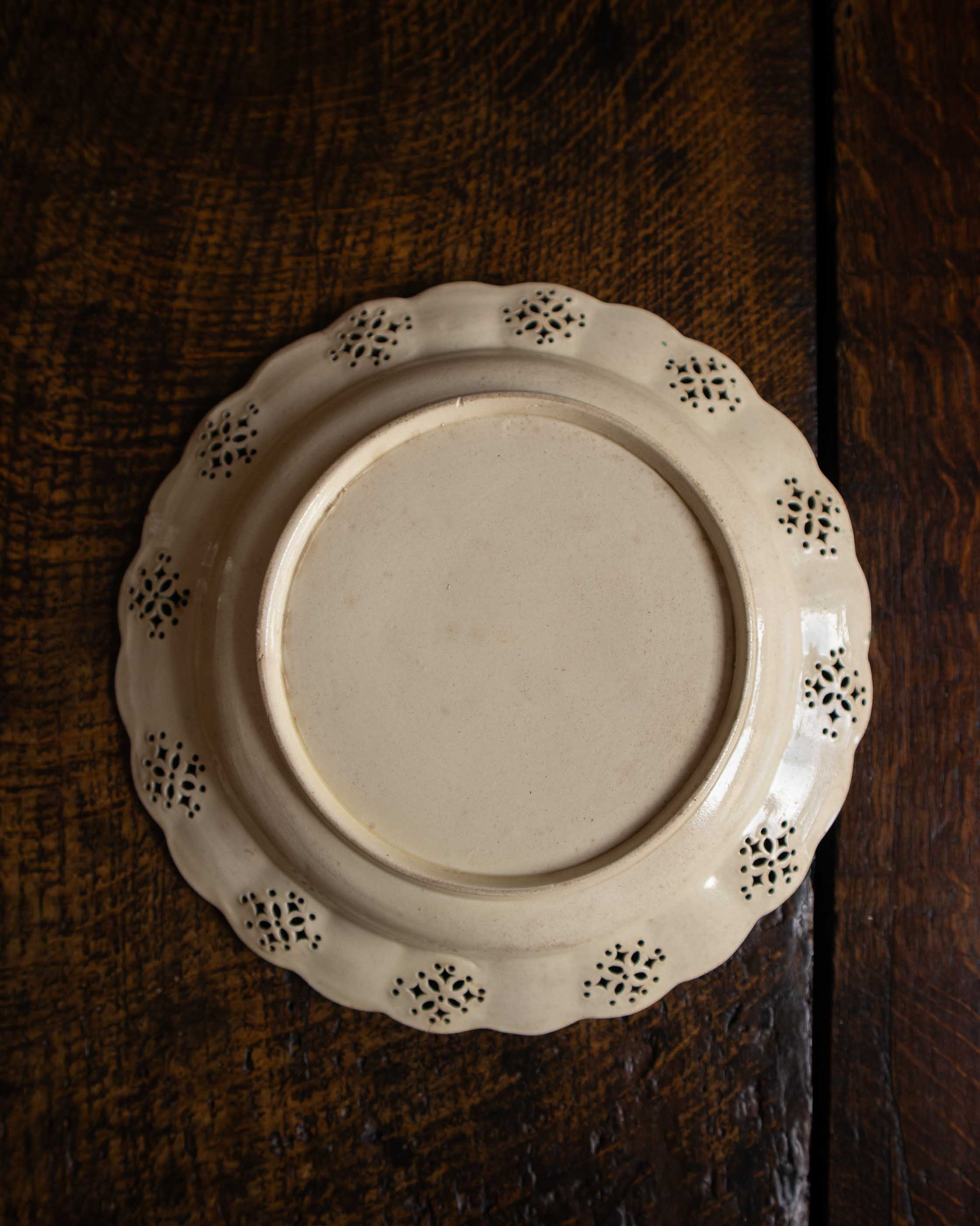 White ceramic plate with decorative edge on a wooden surface