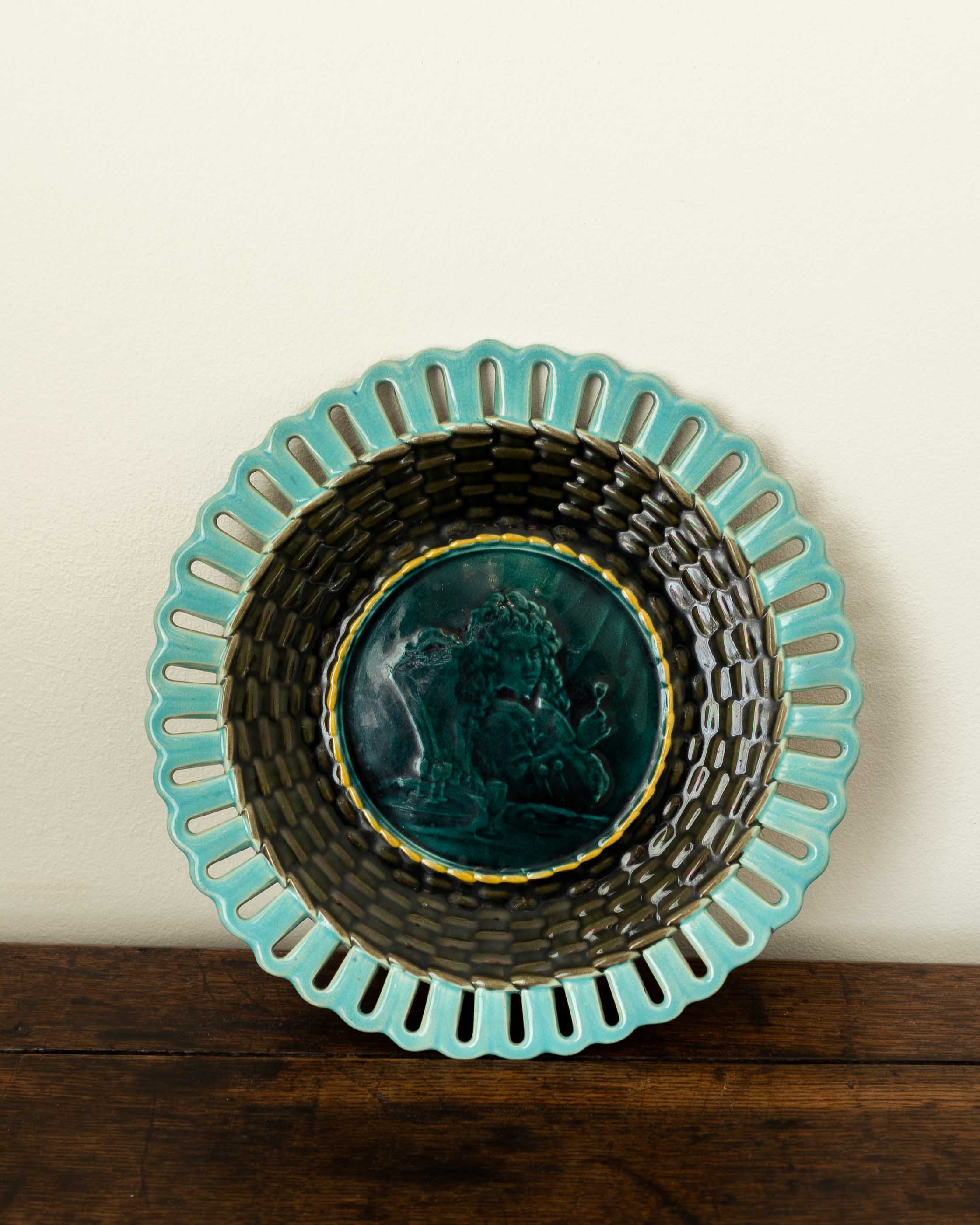 Decorative ceramic plate with turquoise rim and black interior on a wooden surface.
