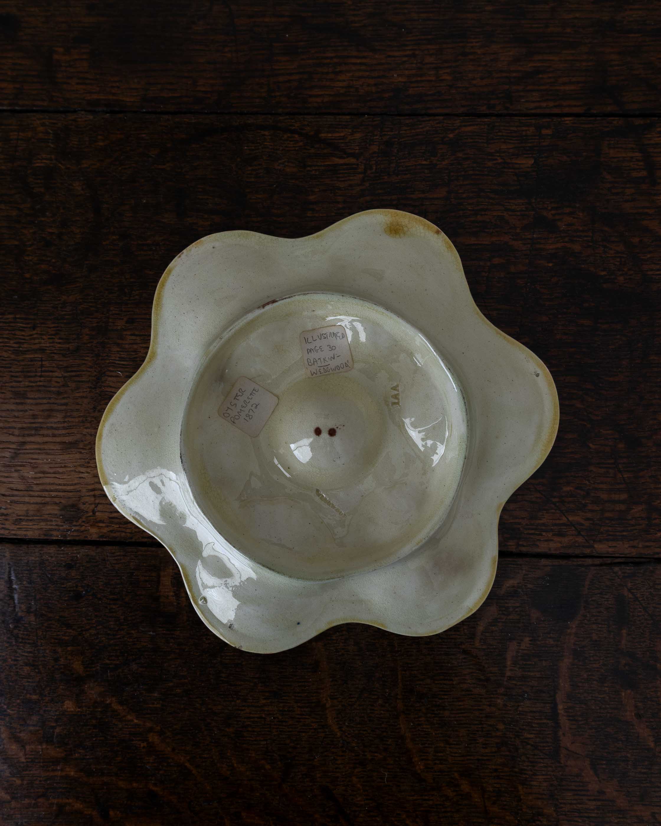 Ceramic oyster plate on a wooden surface with labels on a wooden surface