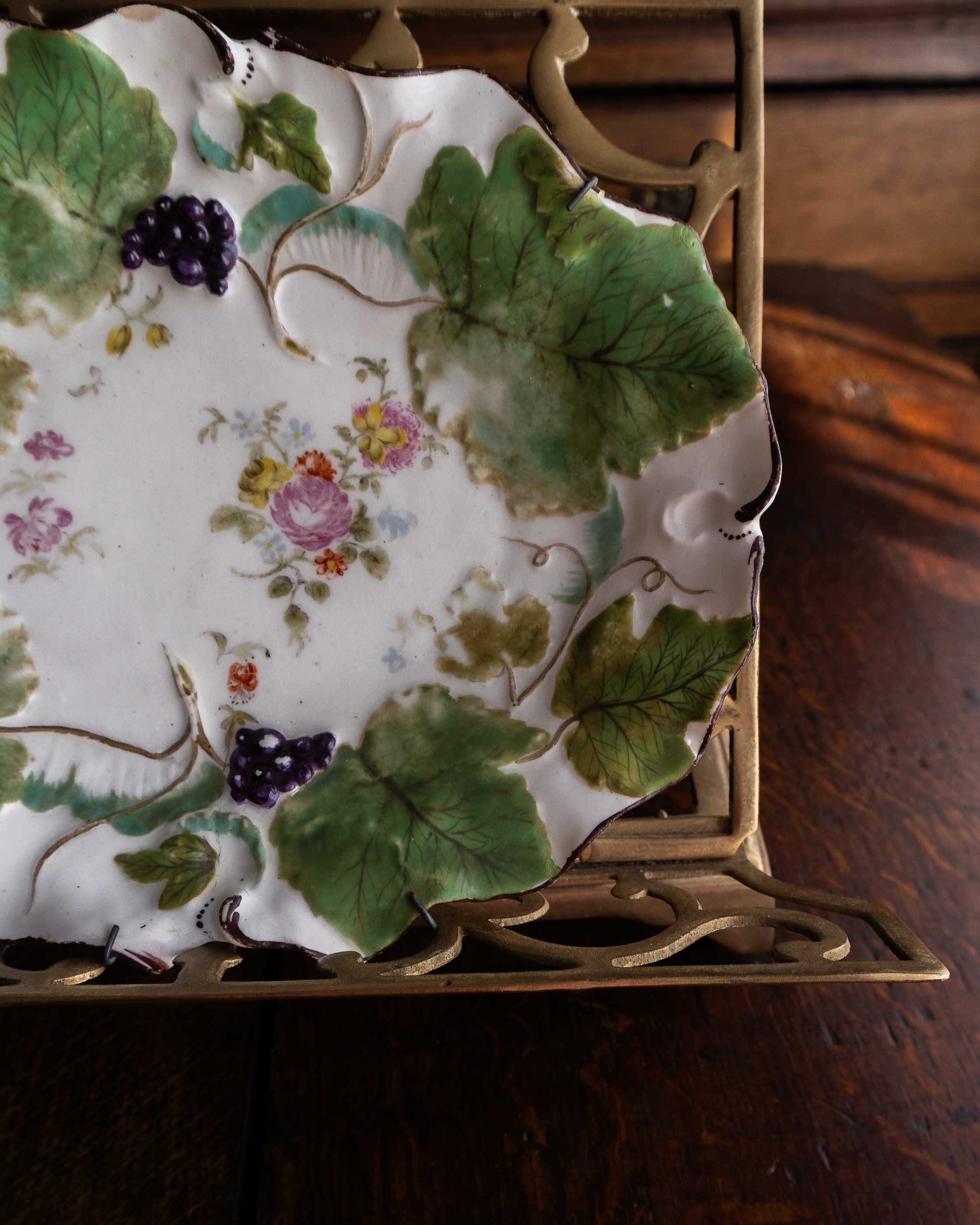 Decorative plate with floral and leaf patterns on a wooden surface