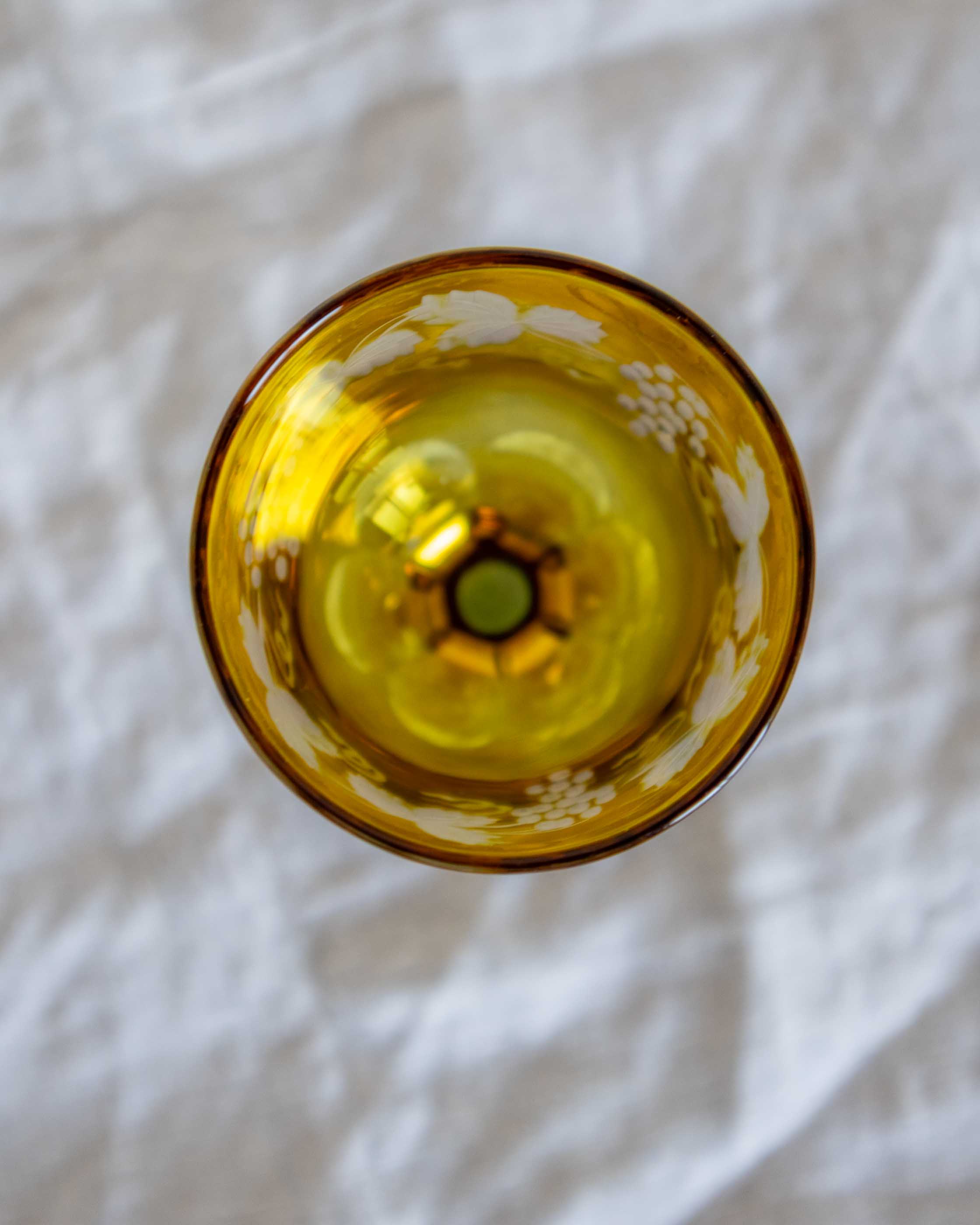 Yellow glass object on a white fabric background
