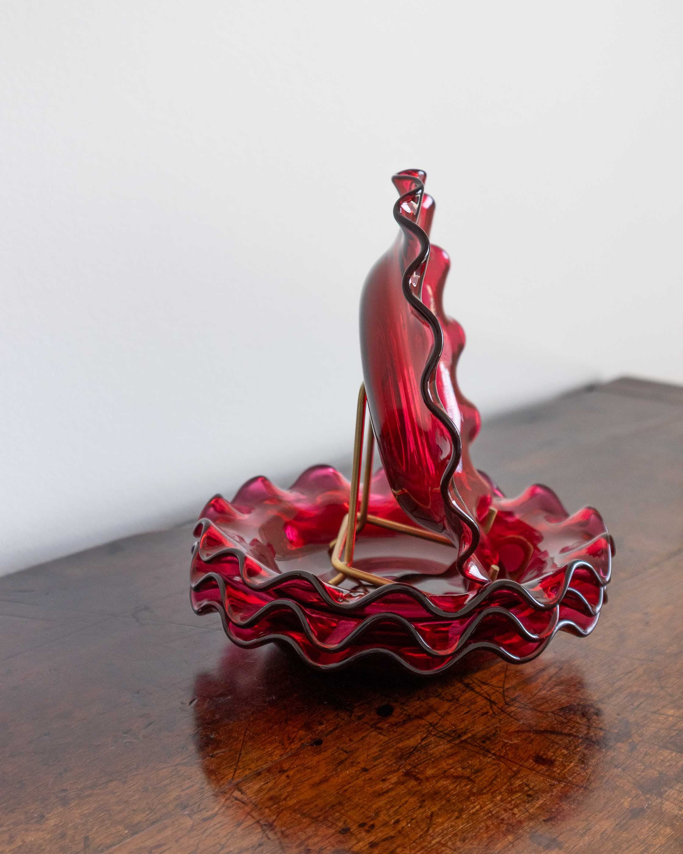 Red glass bowls on a wooden surface with a white background