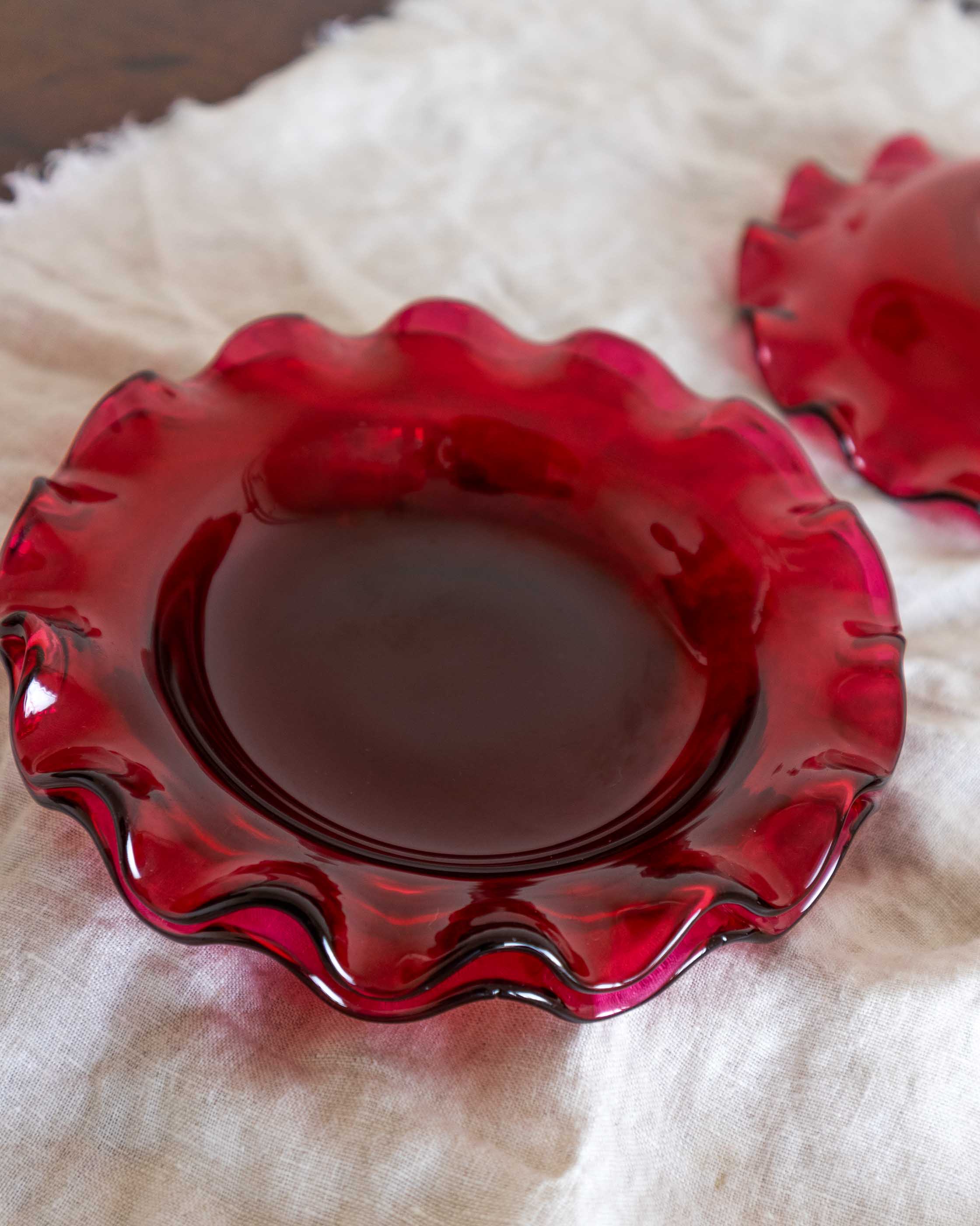 Red glass dish on a textured white surface