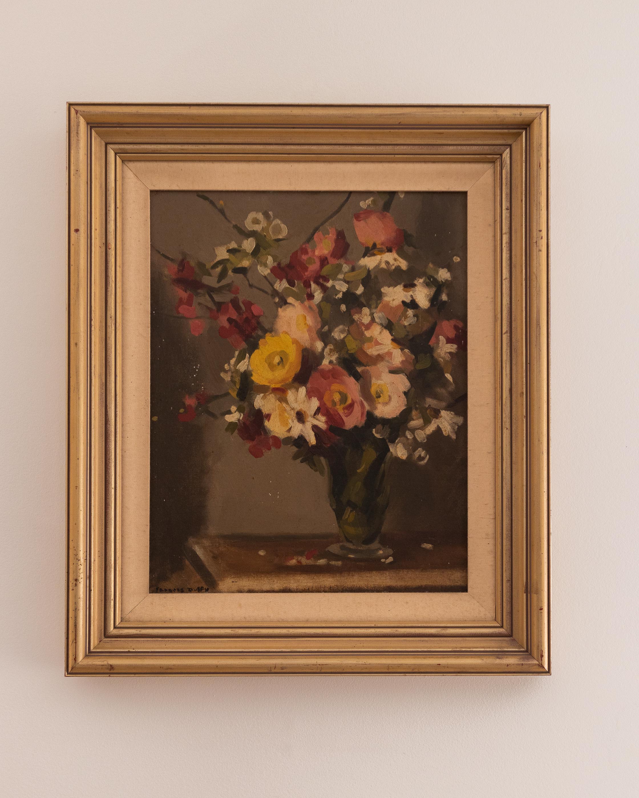 Framed painting of a still life with flowers on a beige wall