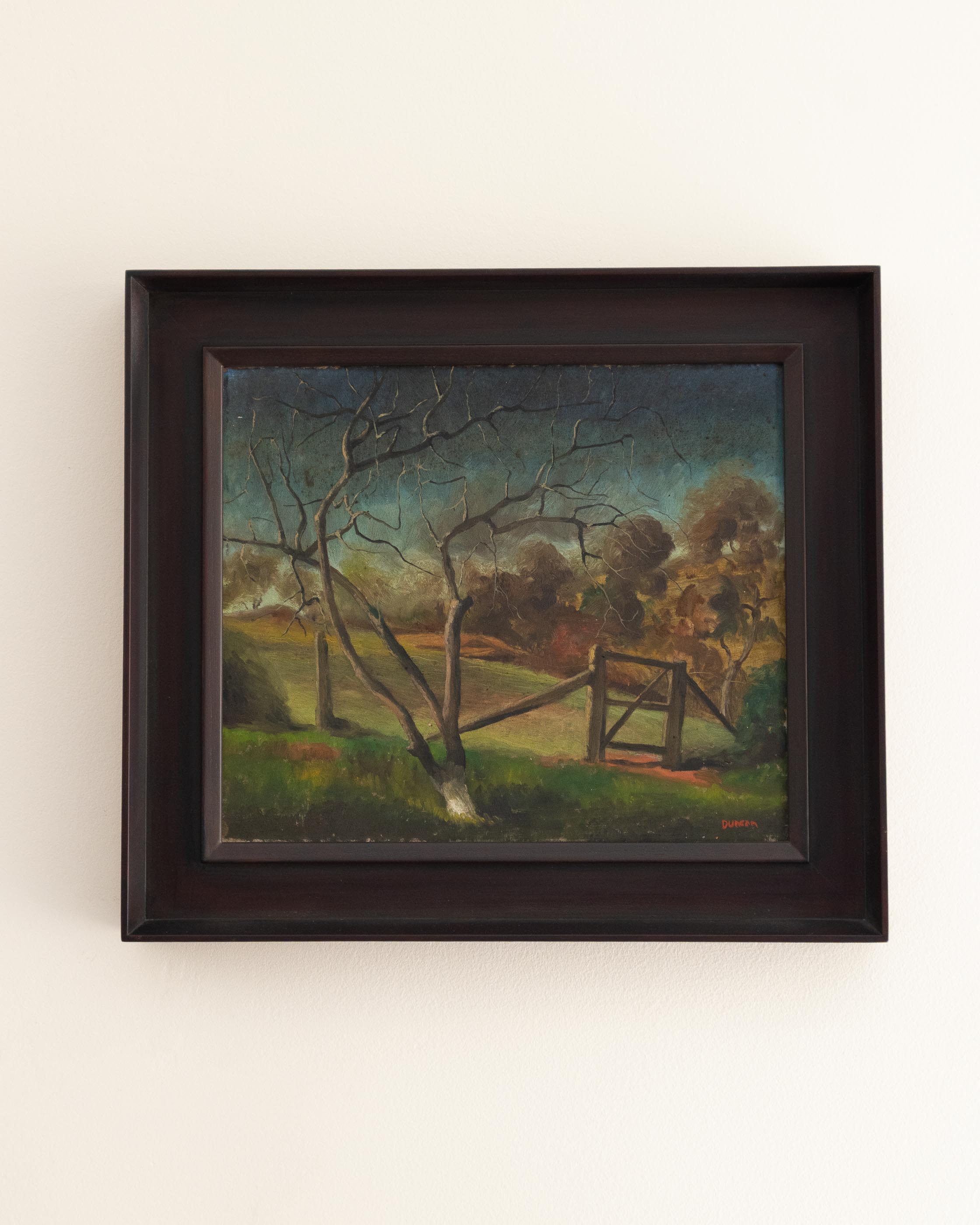 Framed painting of a landscape with a tree and fence on a white wall