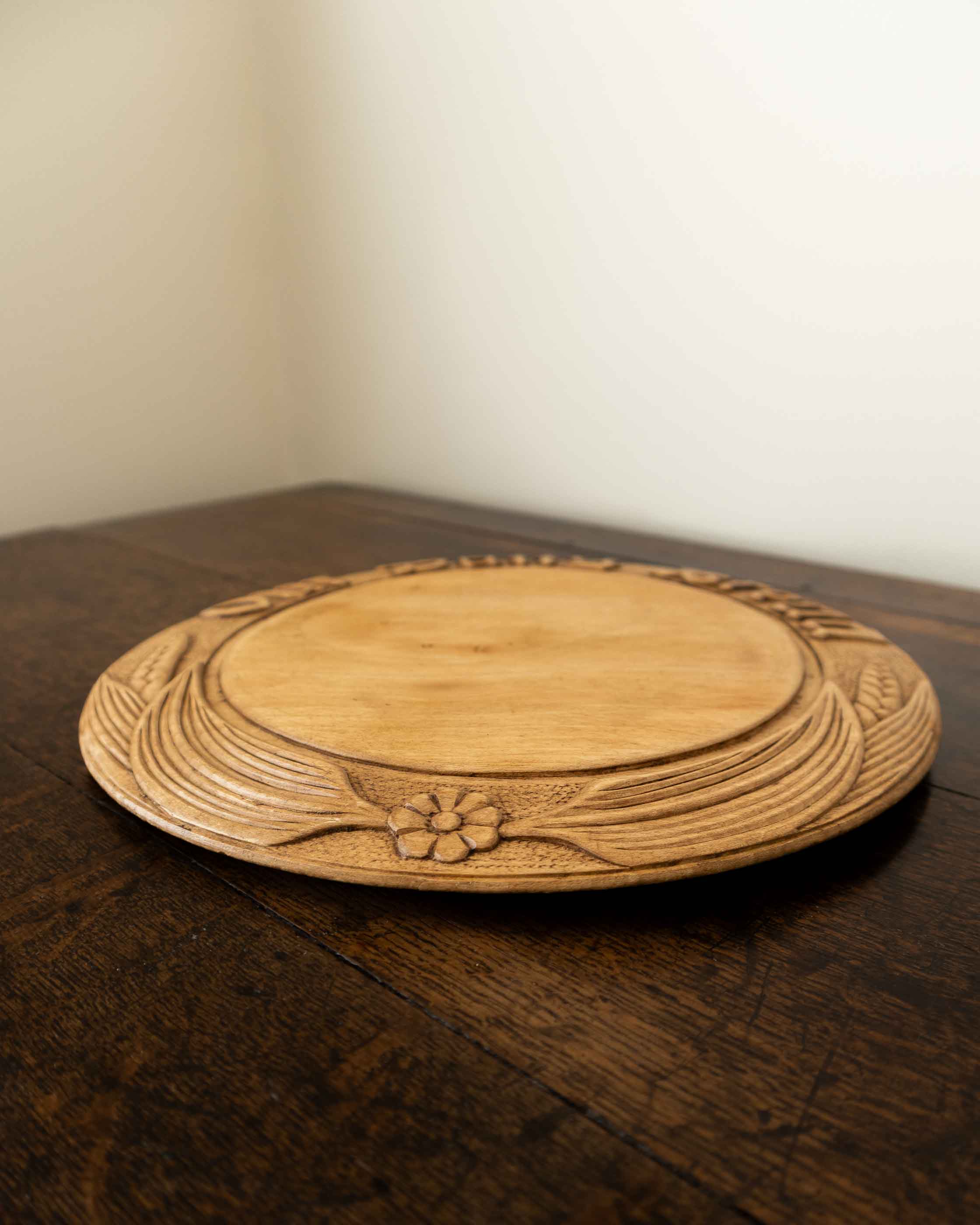 Wooden breadboard with carved text on a wooden surface
