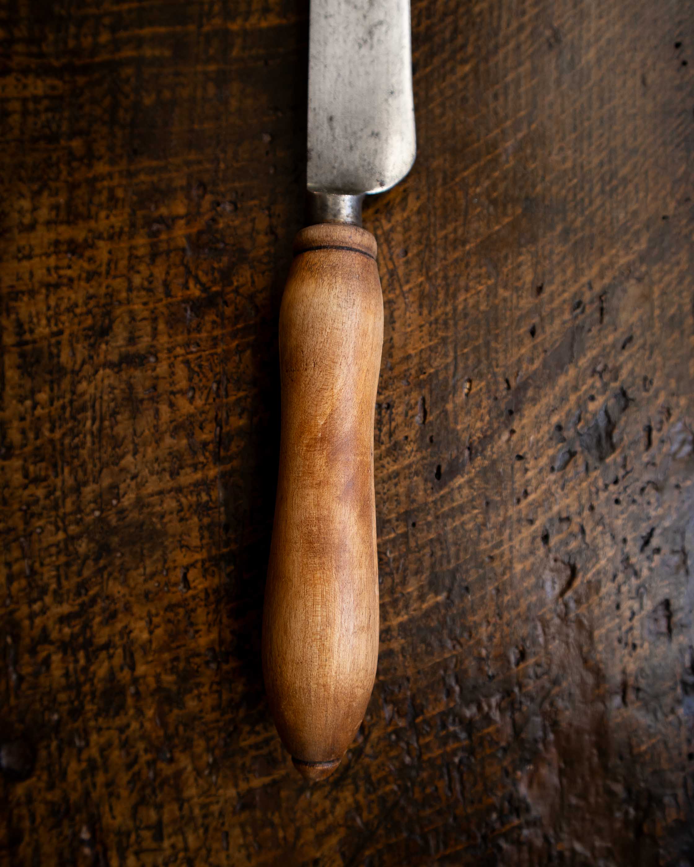 Wooden-handled knife on a dark wooden surface