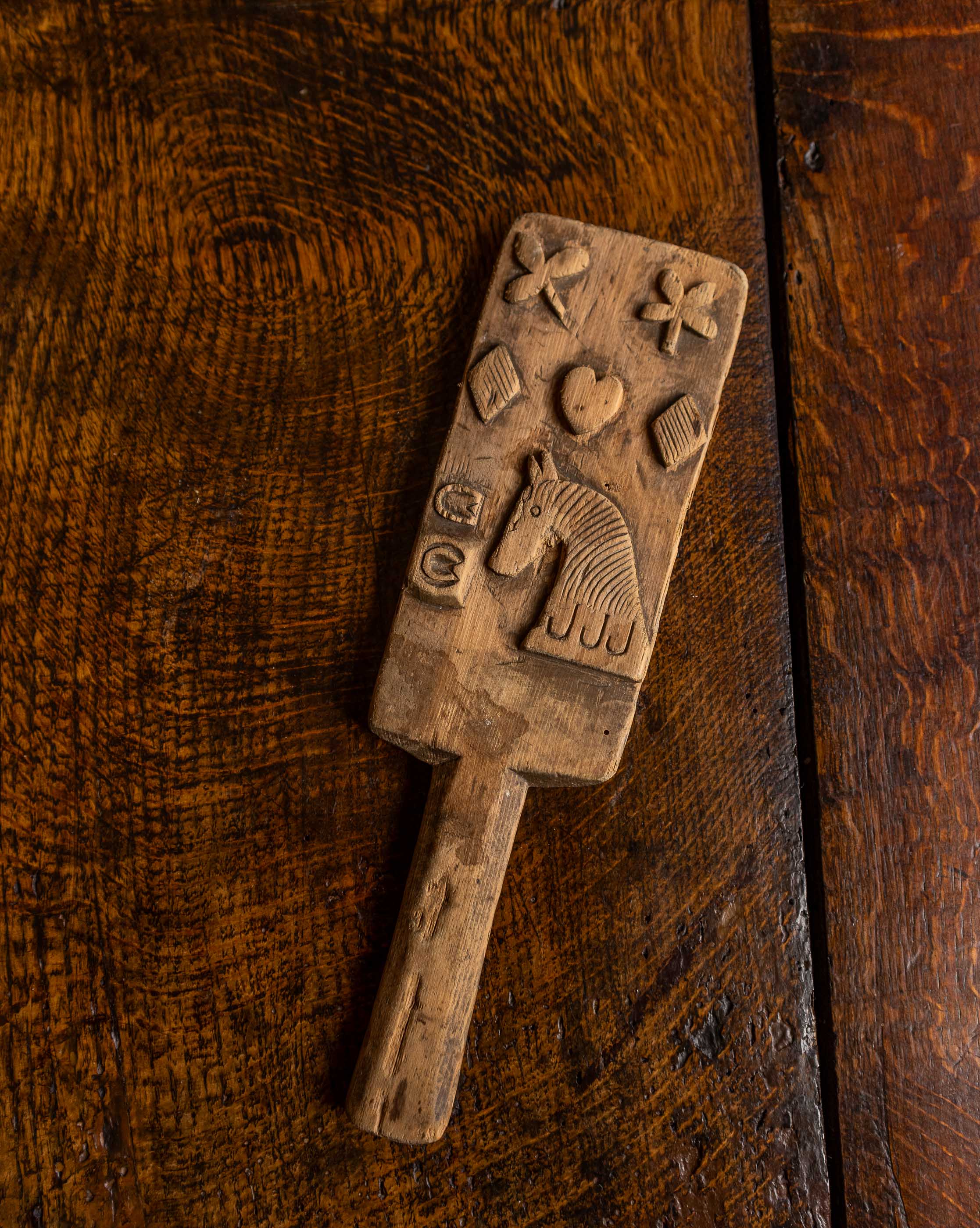 Wooden butter stamp with various shapes on a wooden surface