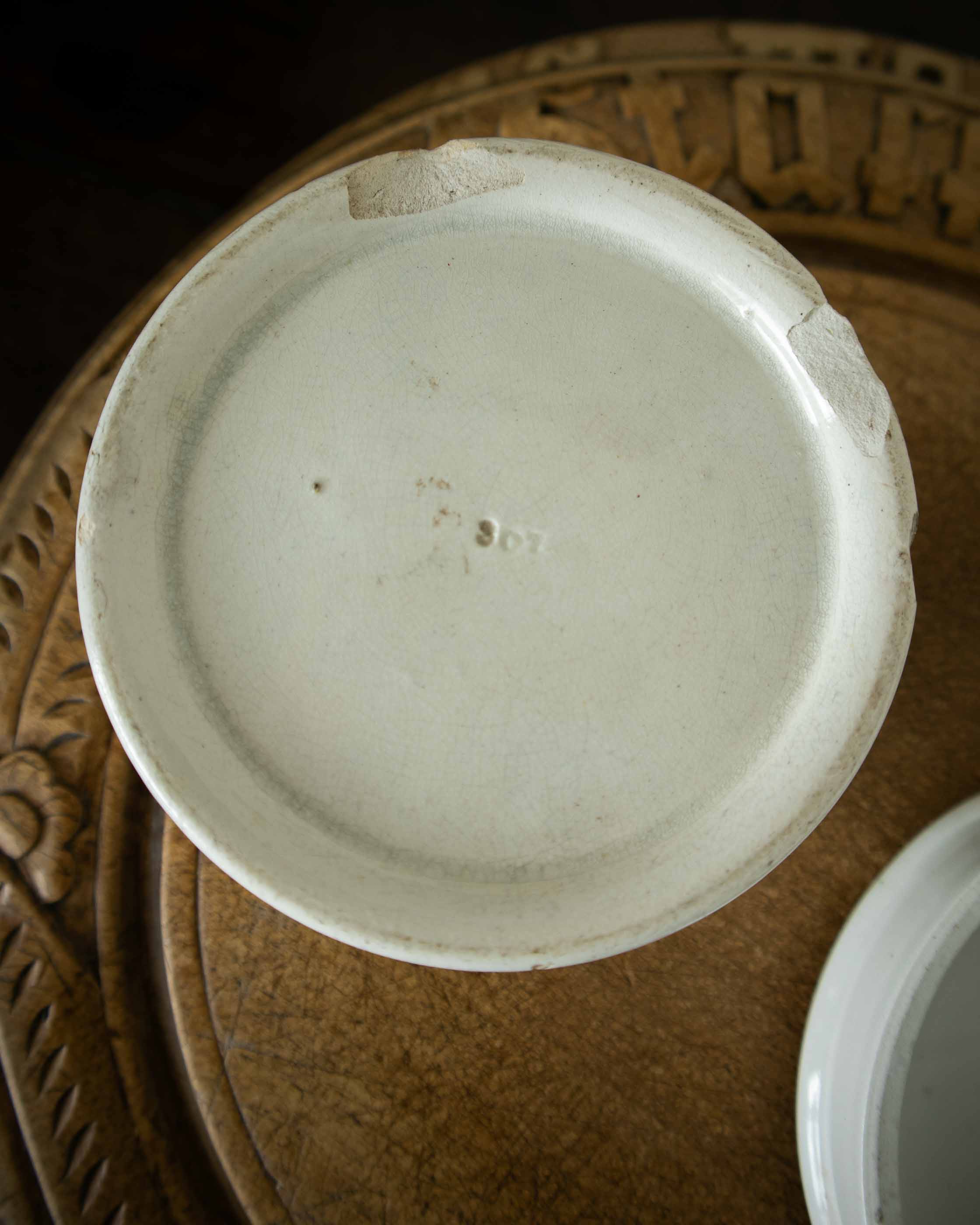 White ceramic pot on a textured brown surface