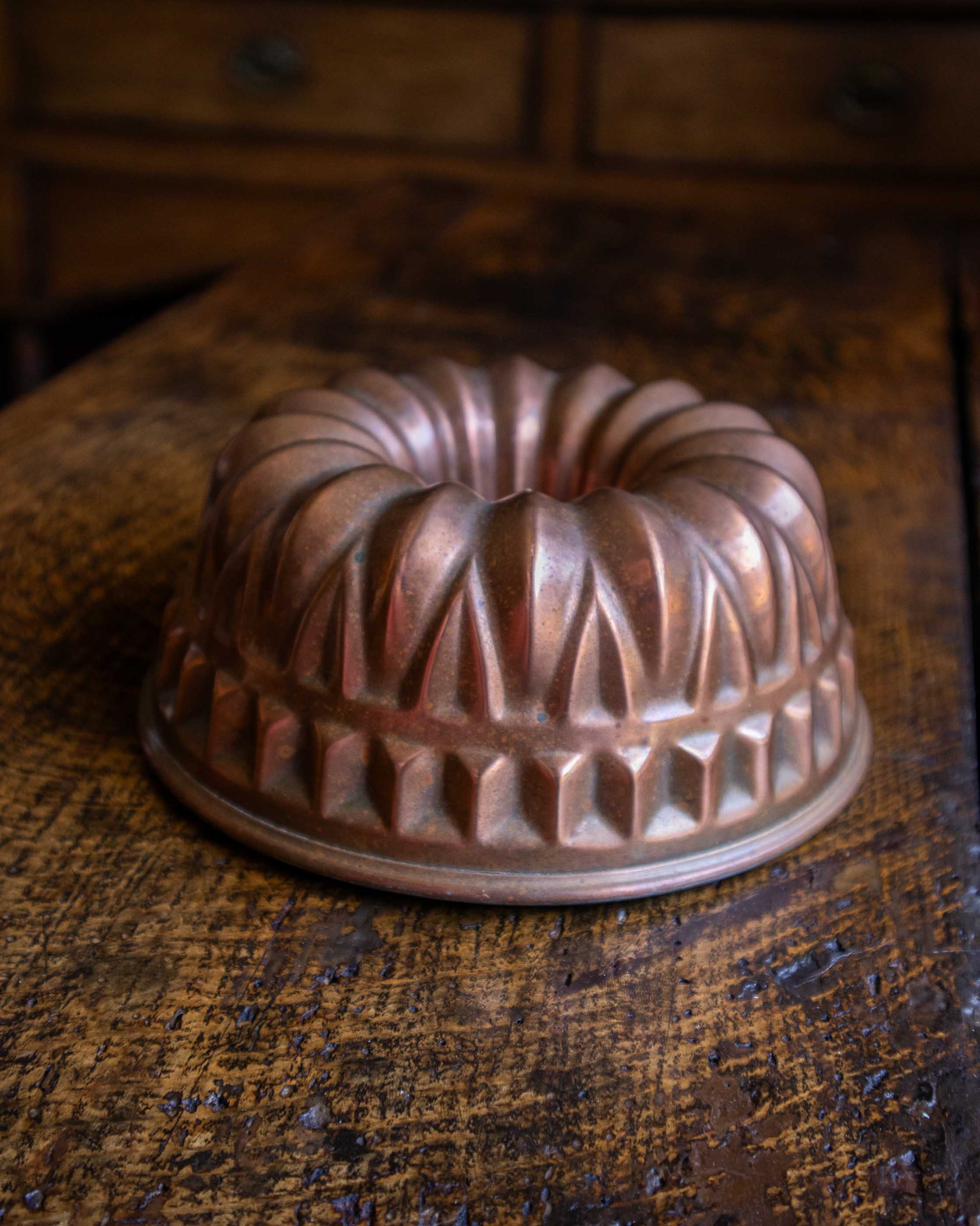 Copper bundt cake mould on a wooden surface