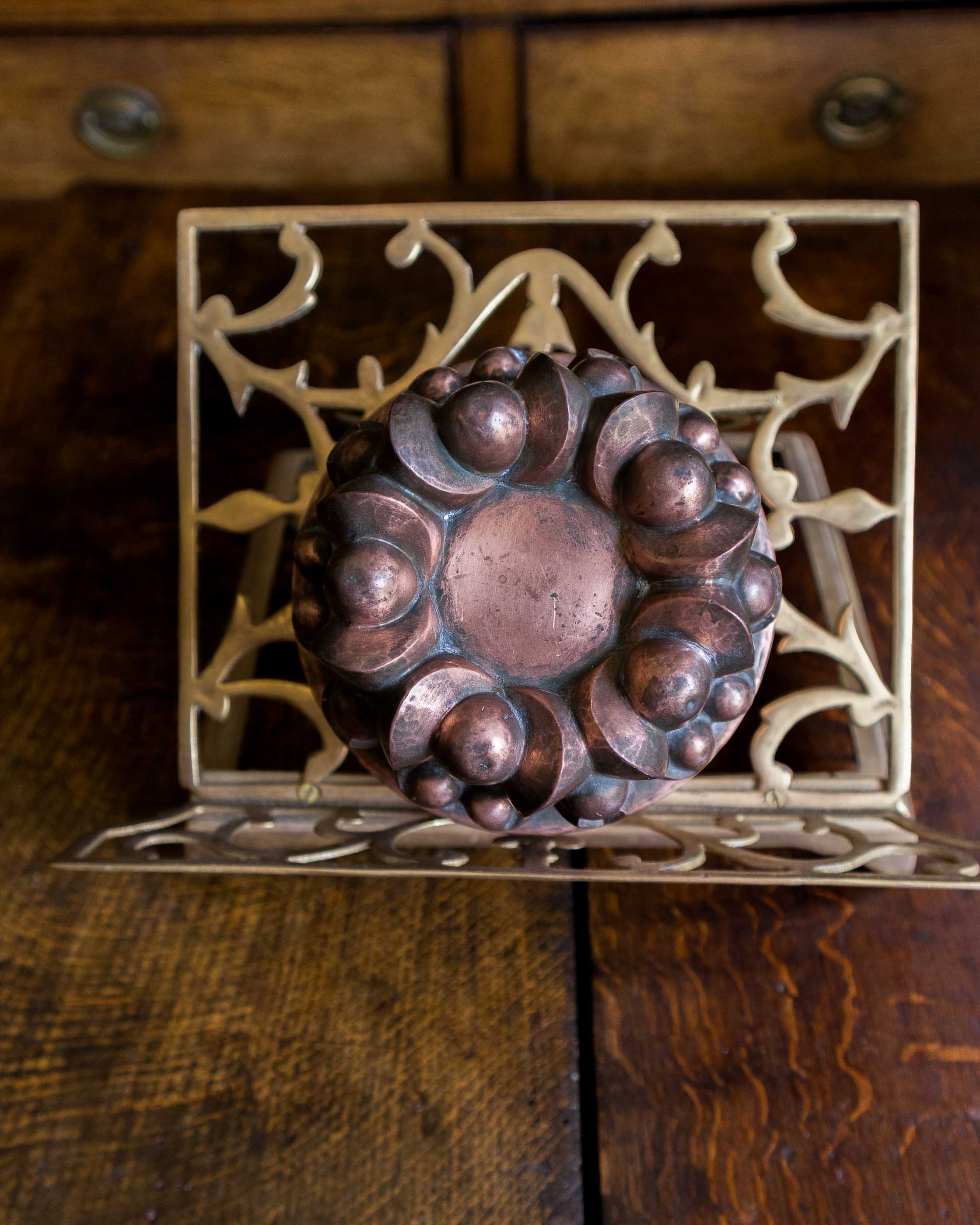 Decorative copper jelly mould on a wooden surface
