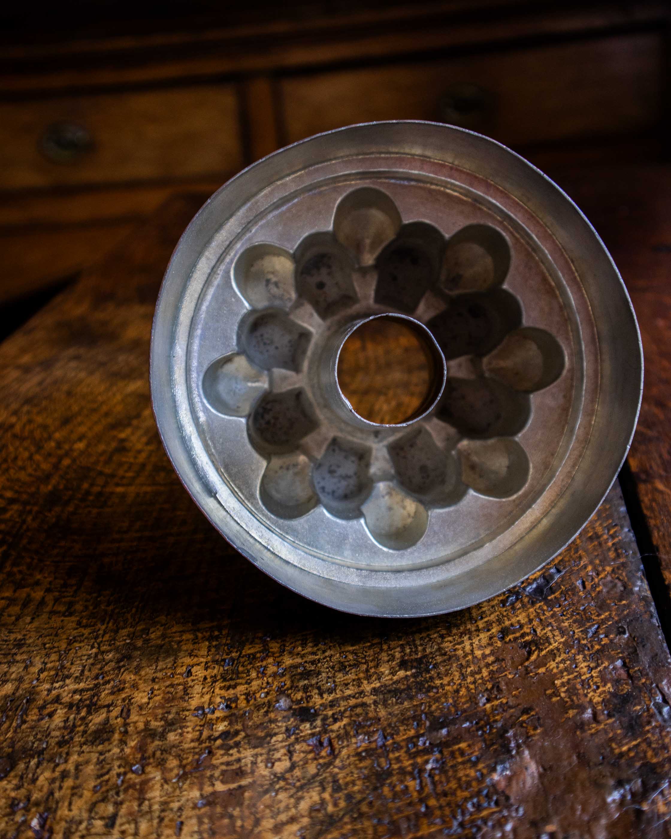 Copper jelly mould with pointed shapes on a wooden surface