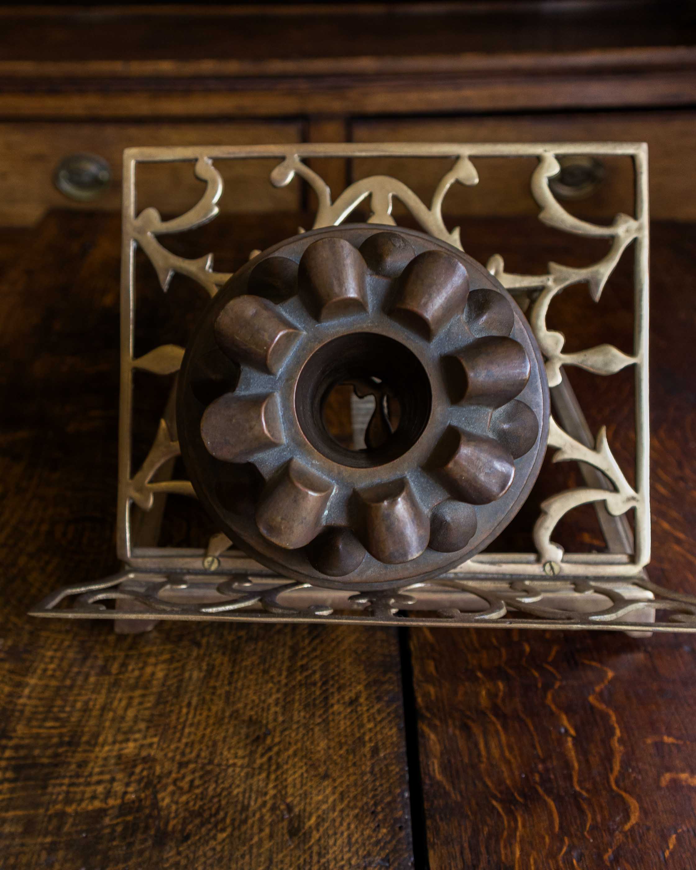 Copper jelly mould with pointed shapes on a wooden surface