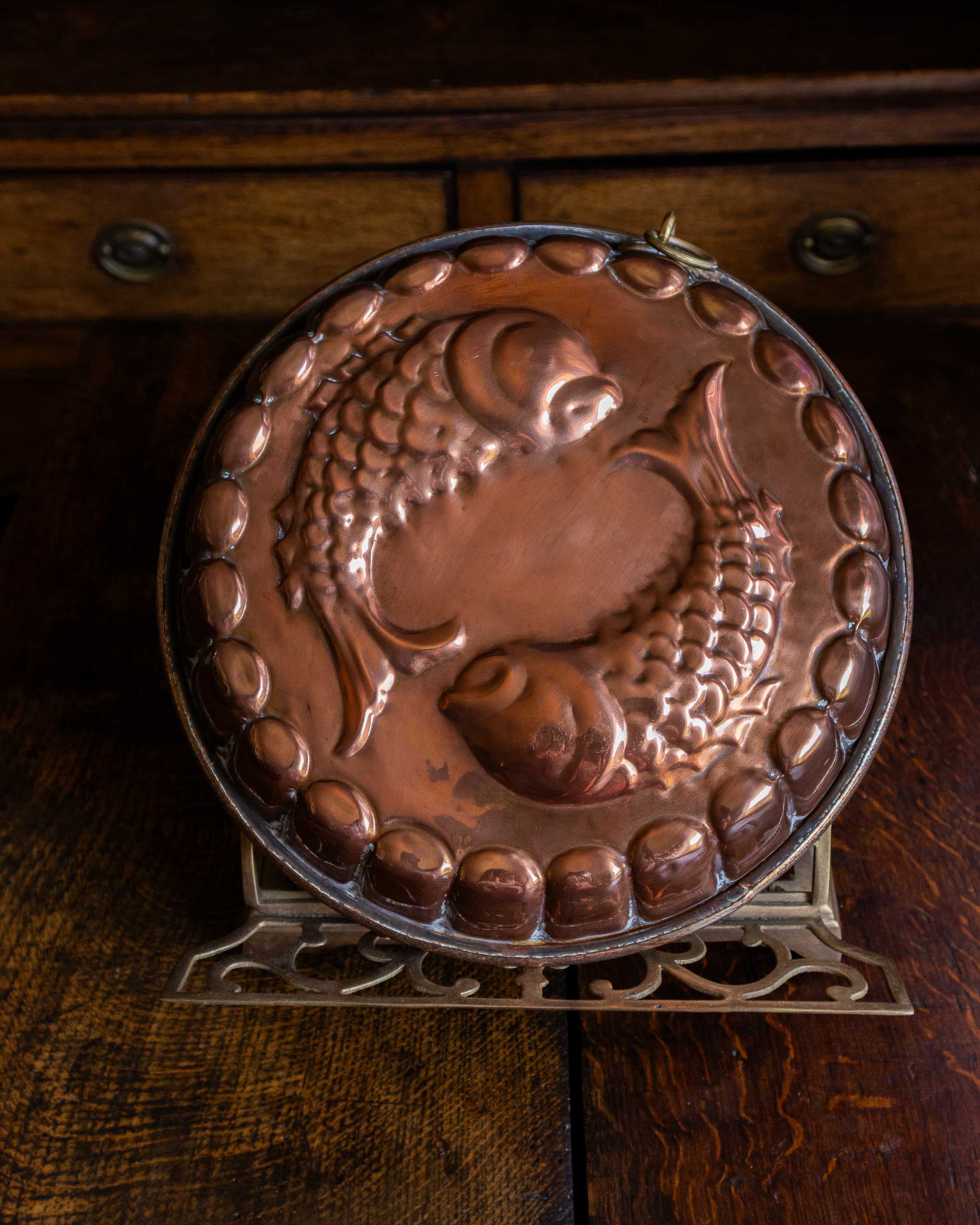 Copper mould with a detailed design on a wooden surface