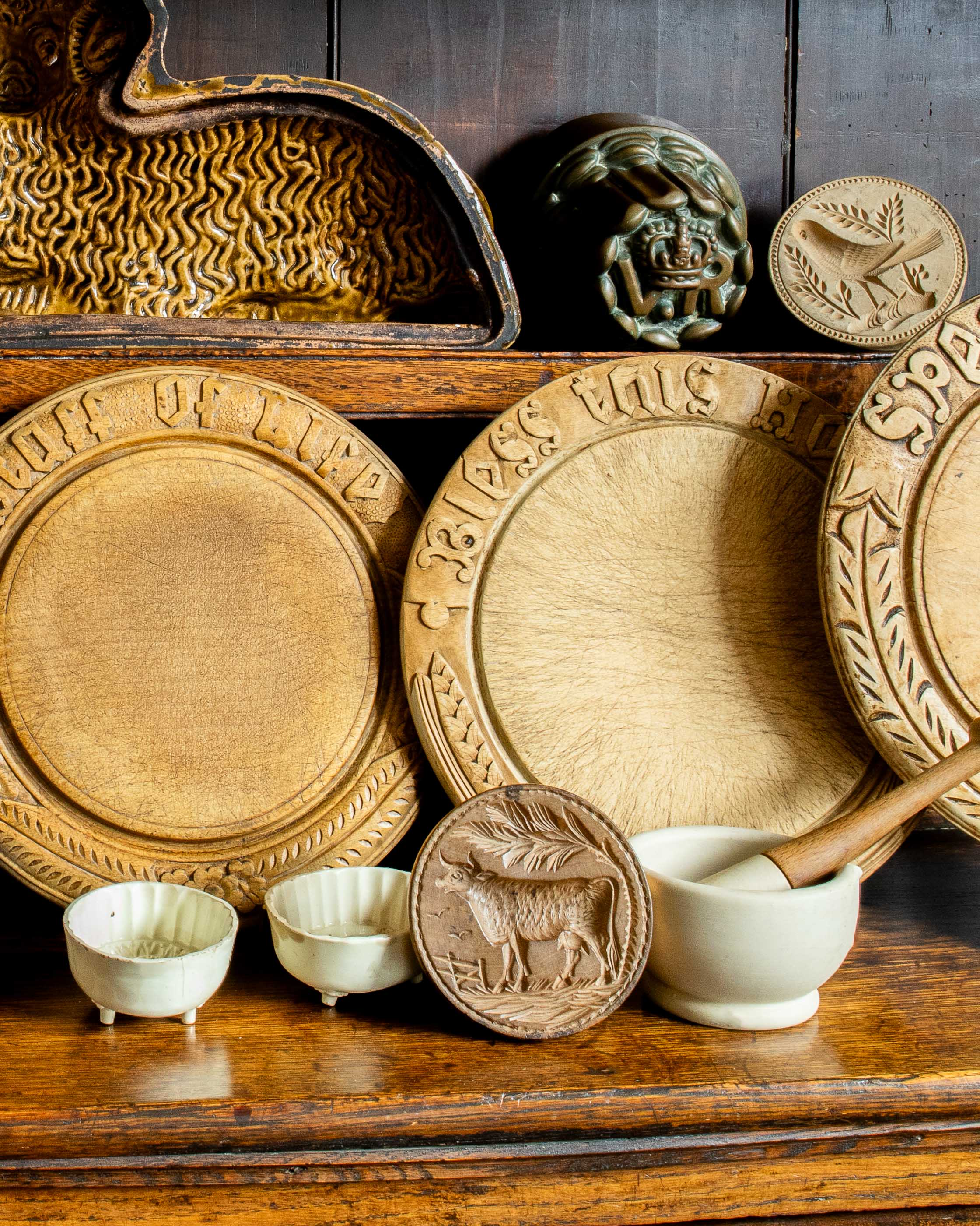 Collection of wooden breadboards and ceramic items on a wooden shelf