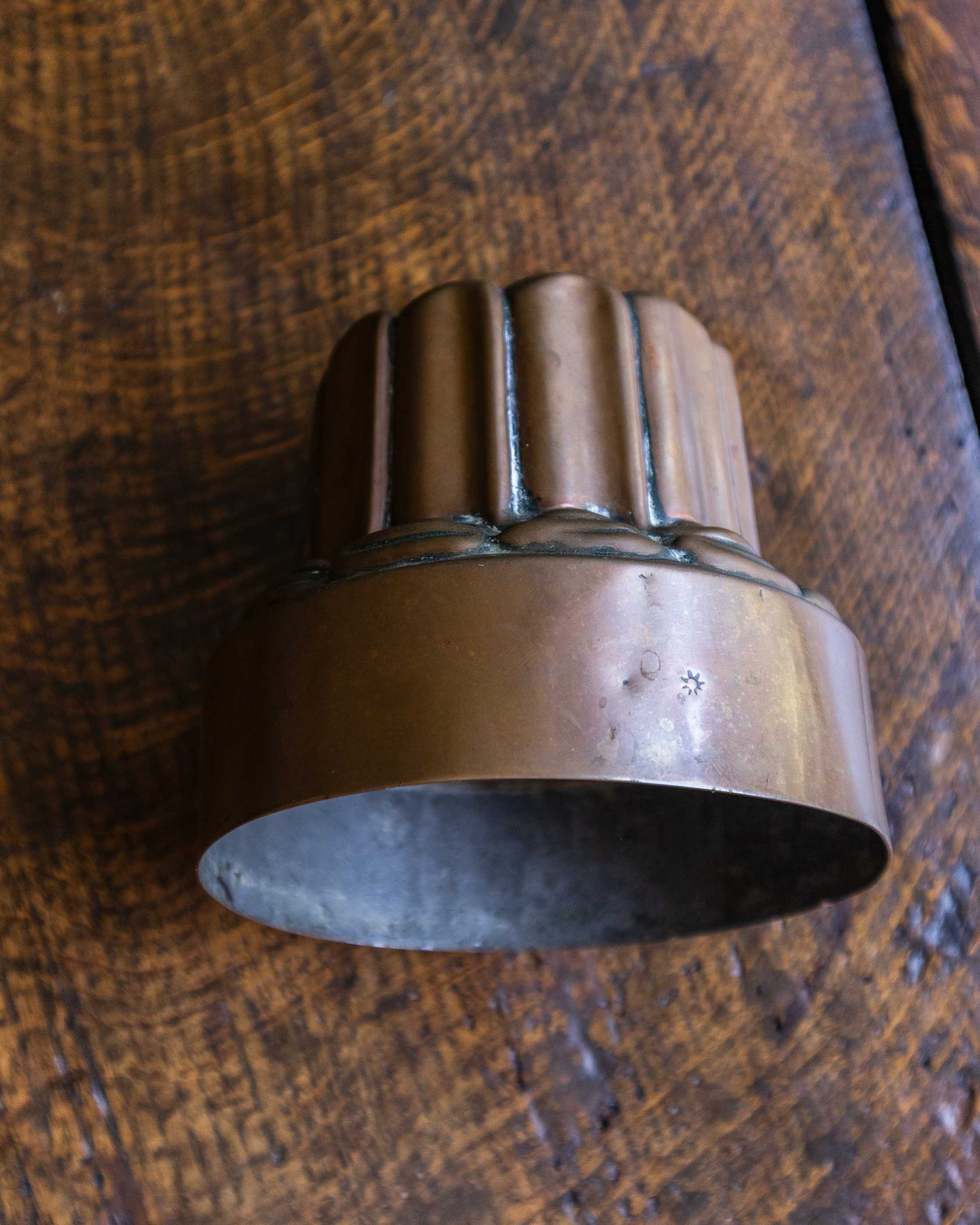 Copper jelly mould on a wooden surface.