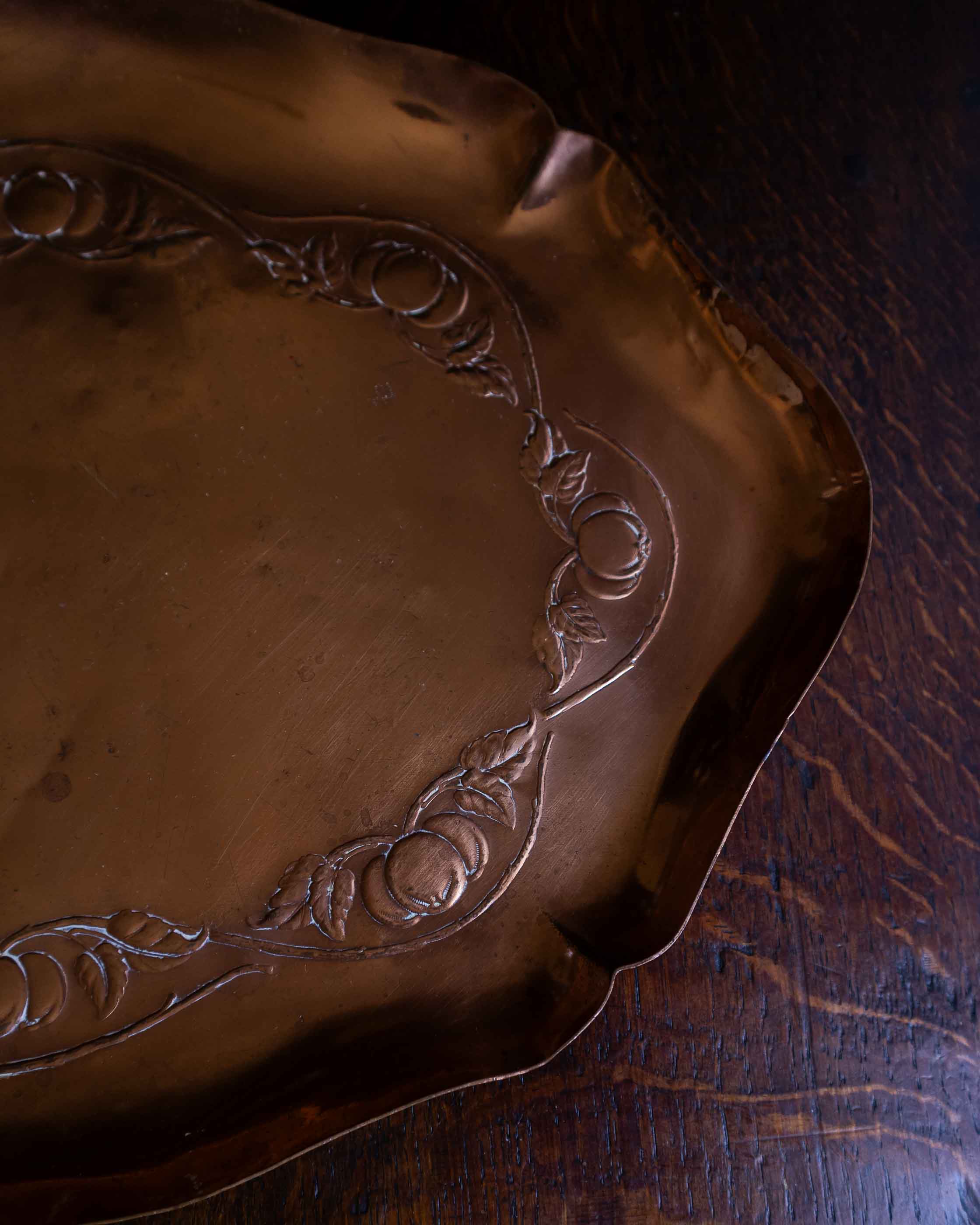 Decorative copper tray on a wooden surface