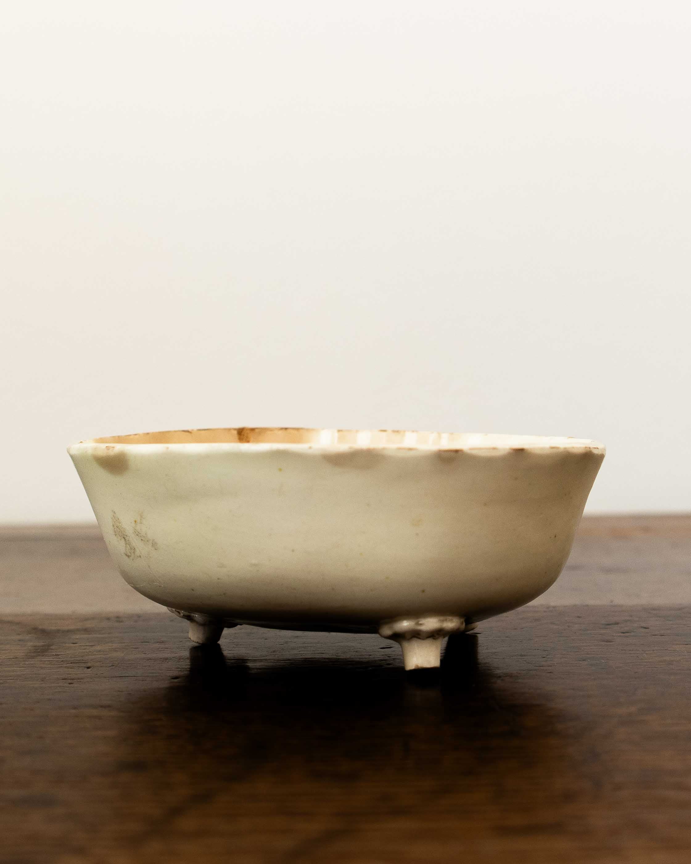 White ceramic mould on a wooden surface with a plain background