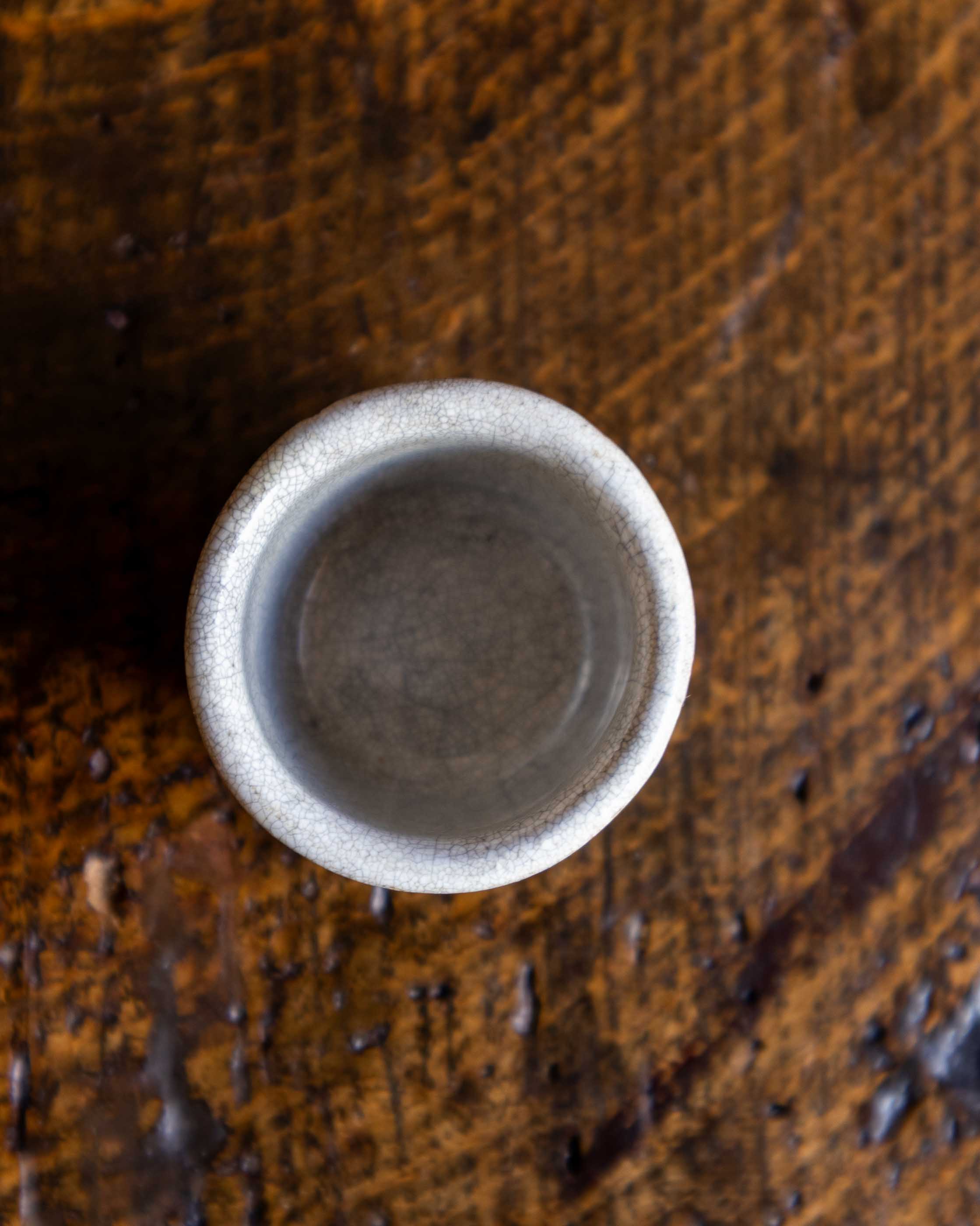 Small ceramic pot on a textured wooden surface