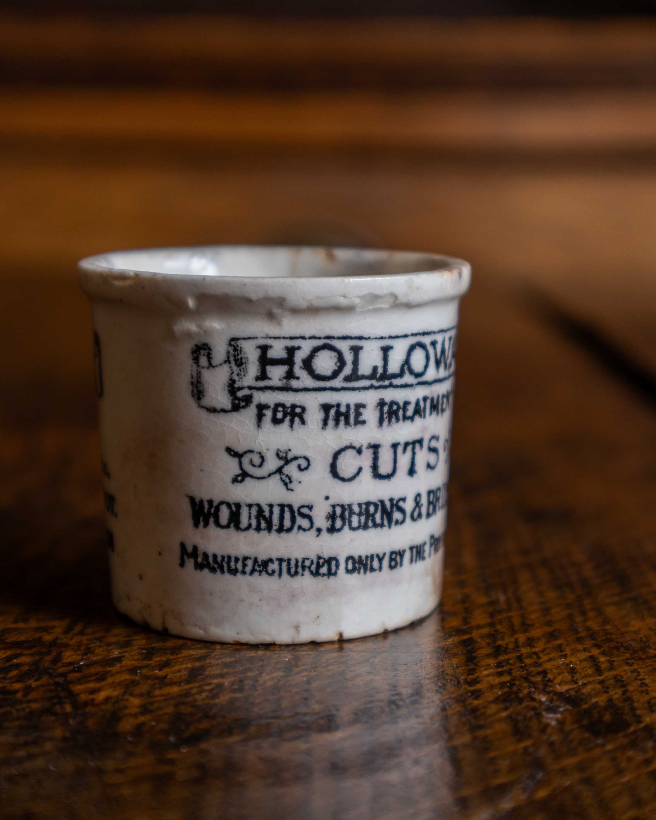 Small ceramic pot with text on a wooden surface