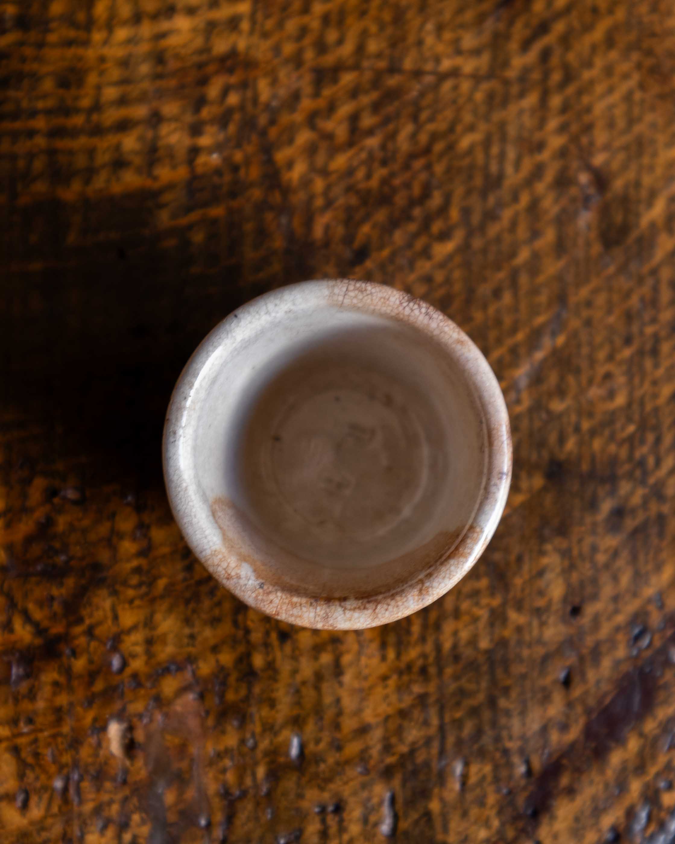 Small ceramic pot on a textured wooden surface