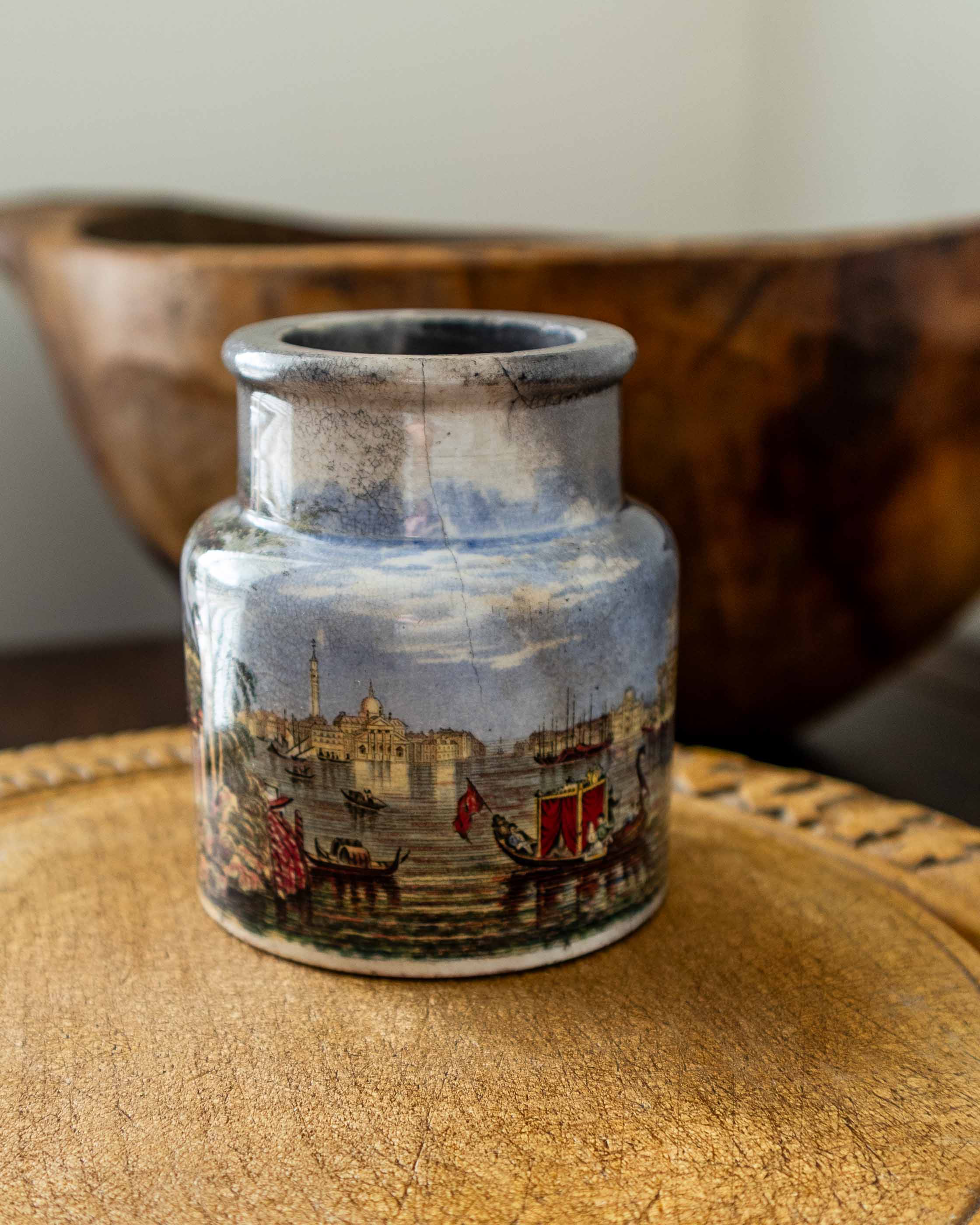Decorative ceramic jar with a scenic design on a textured surface