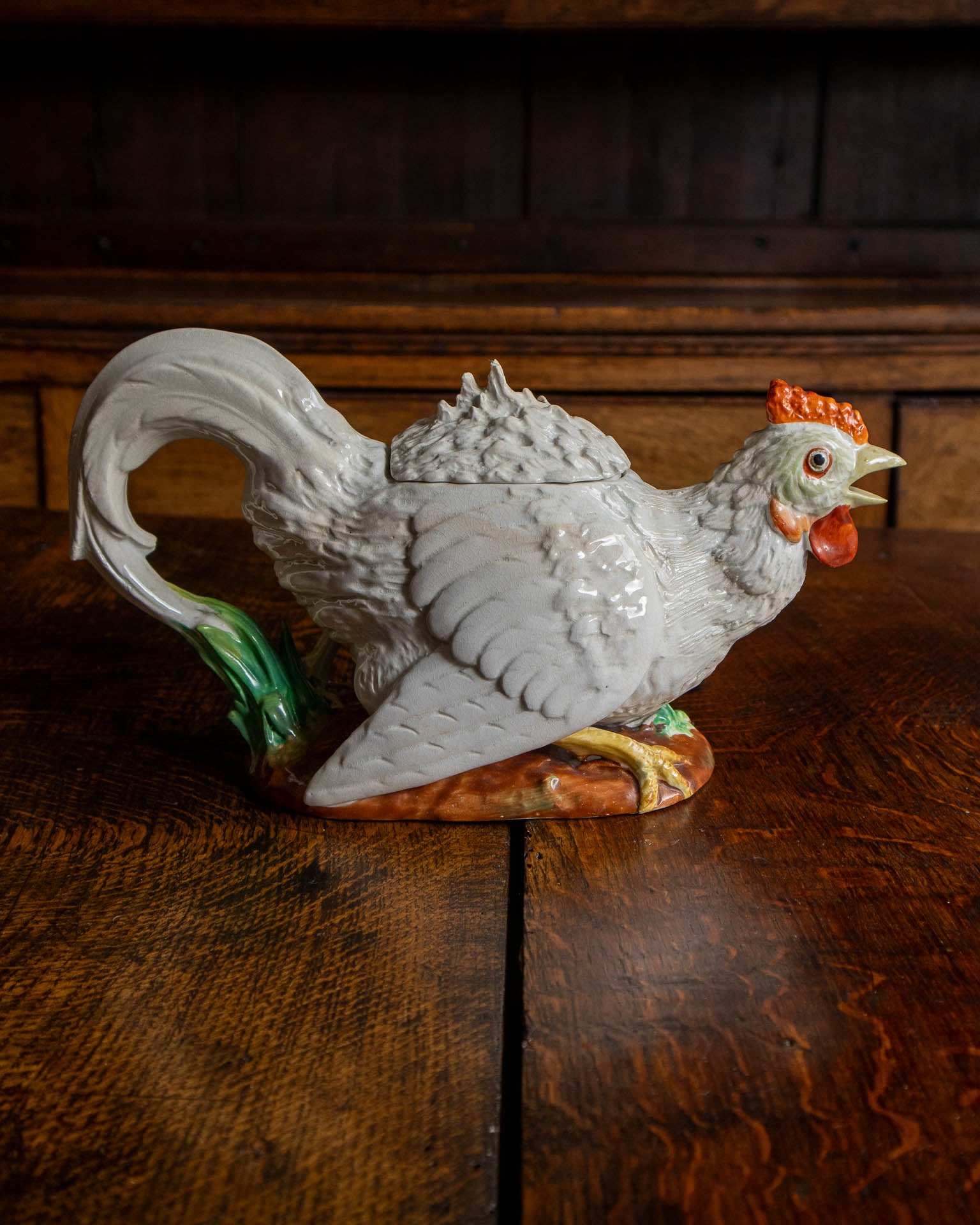 Decorative ceramic rooster teapot on a wooden surface
