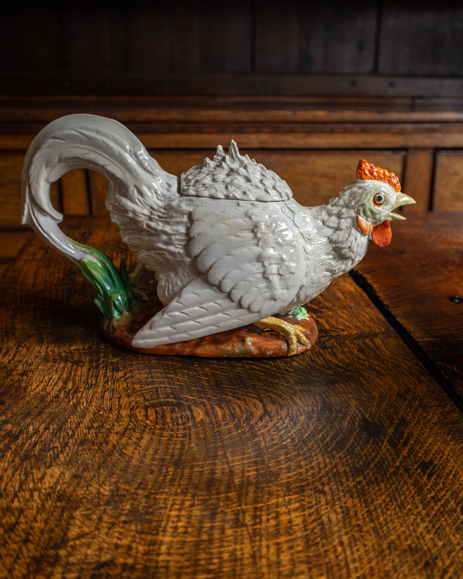 Decorative ceramic rooster teapot on a wooden surface