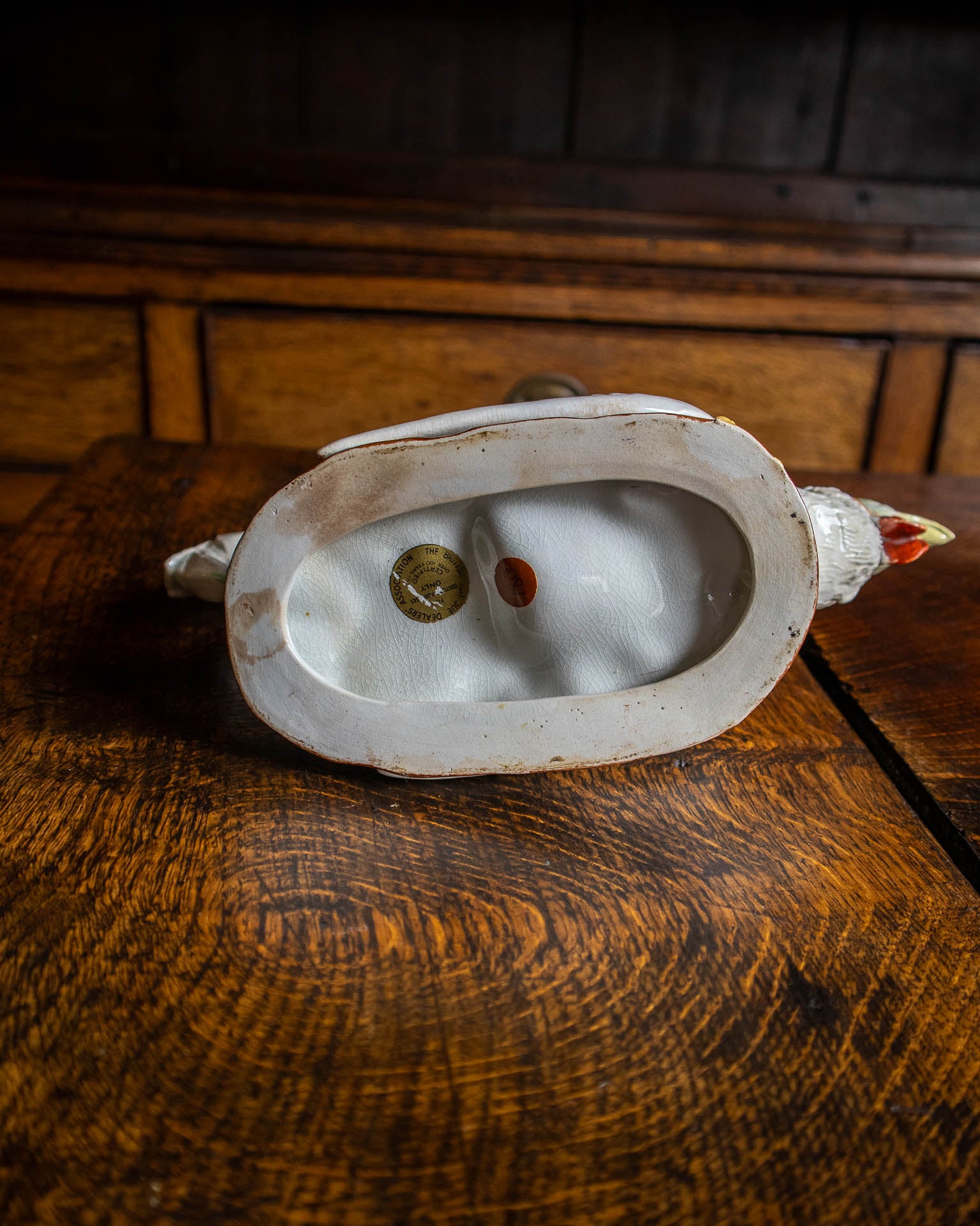 Decorative rooster teapot on a wooden background