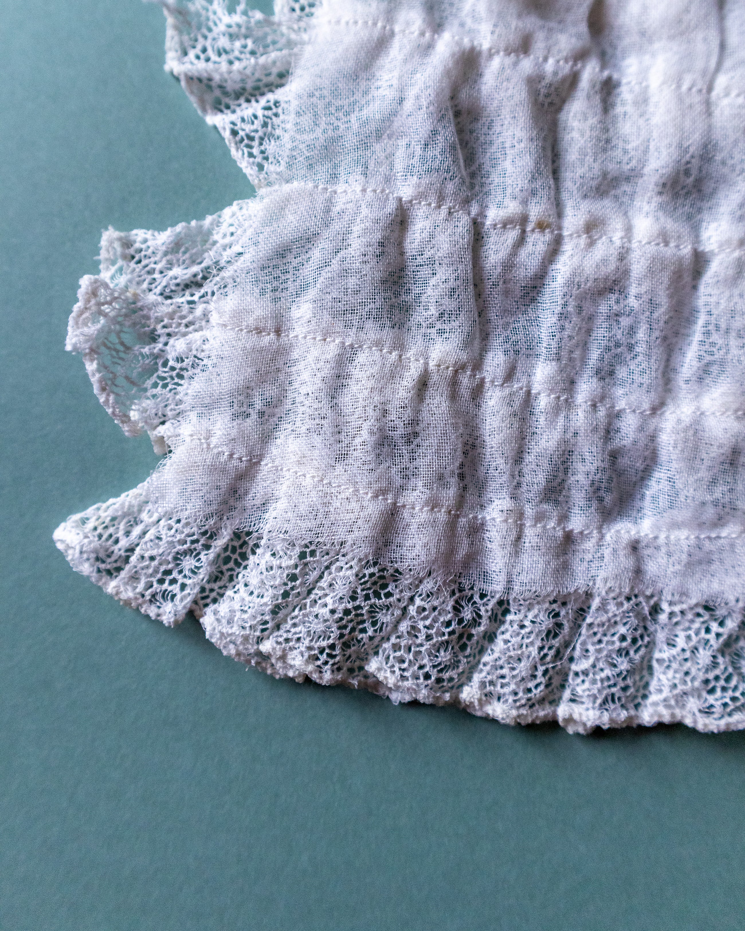 Close-up of lace fabric on a teal background