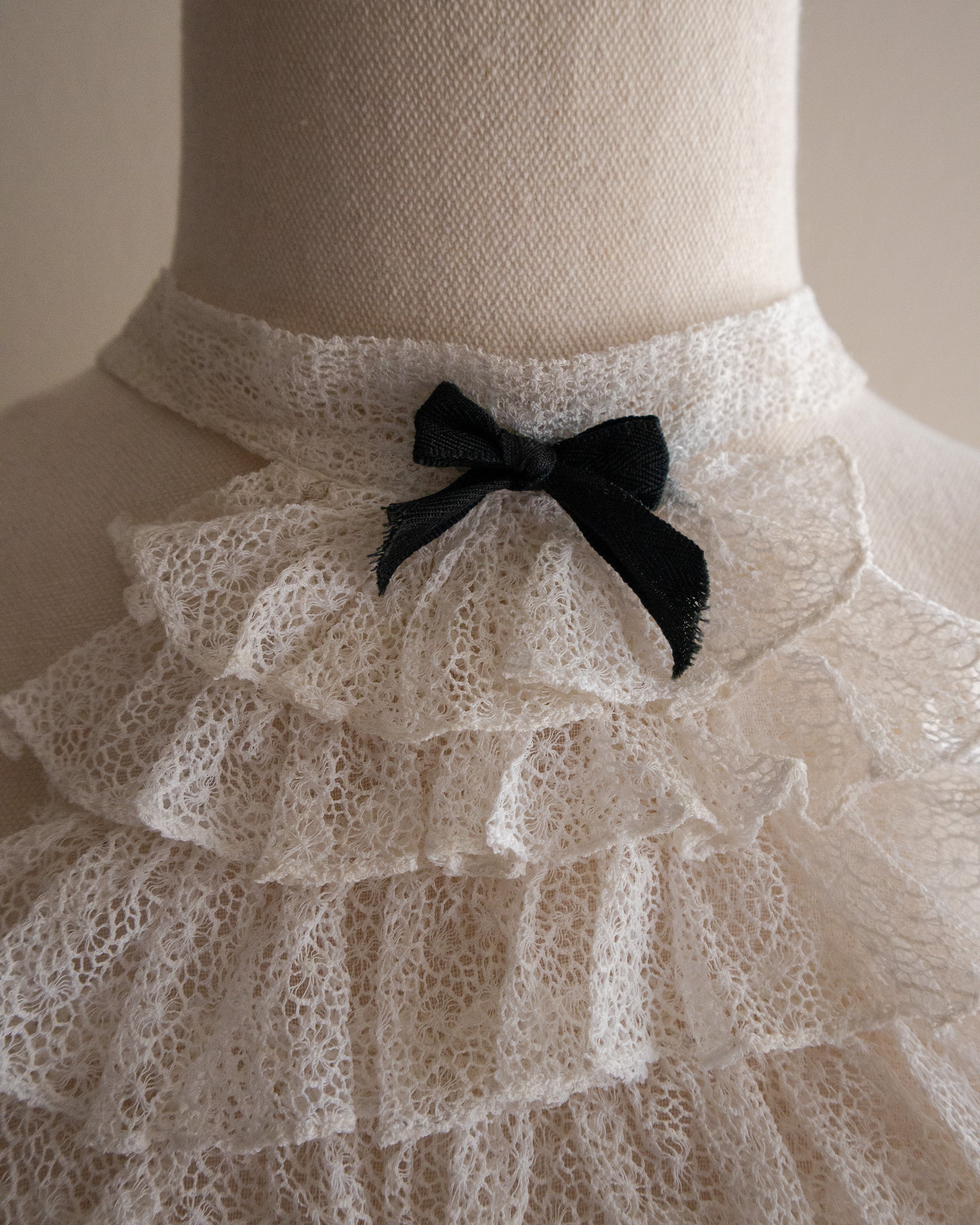 Mannequin wearing a lace jabot with a black bow
