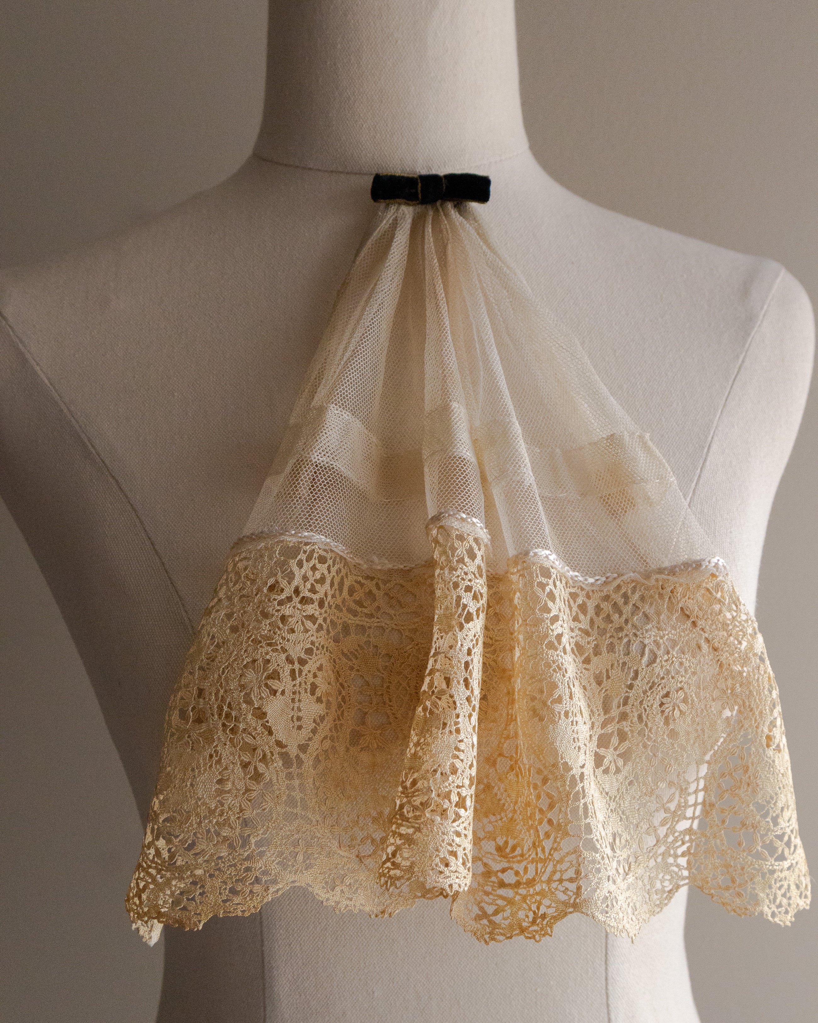 Lace jabot on a mannequin against a neutral background