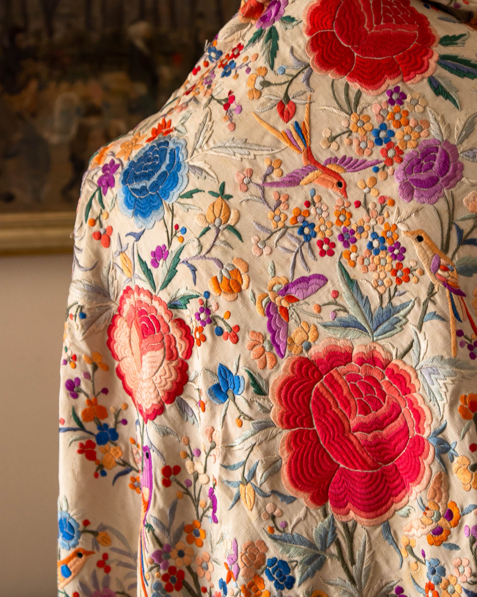 Close-up of a scarf with intricate floral and bird embroidery.