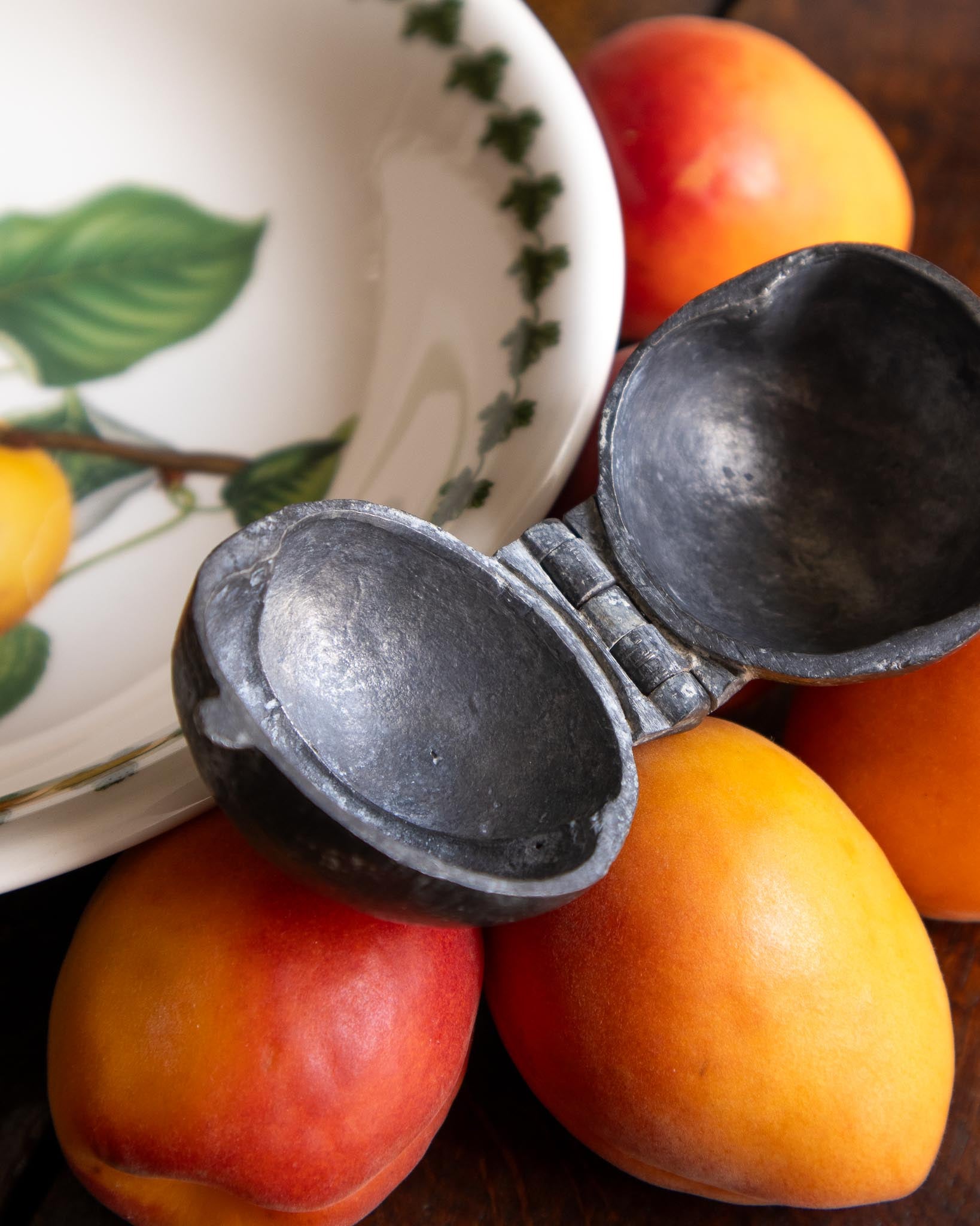 Pewter mould with apricots on a wooden surface