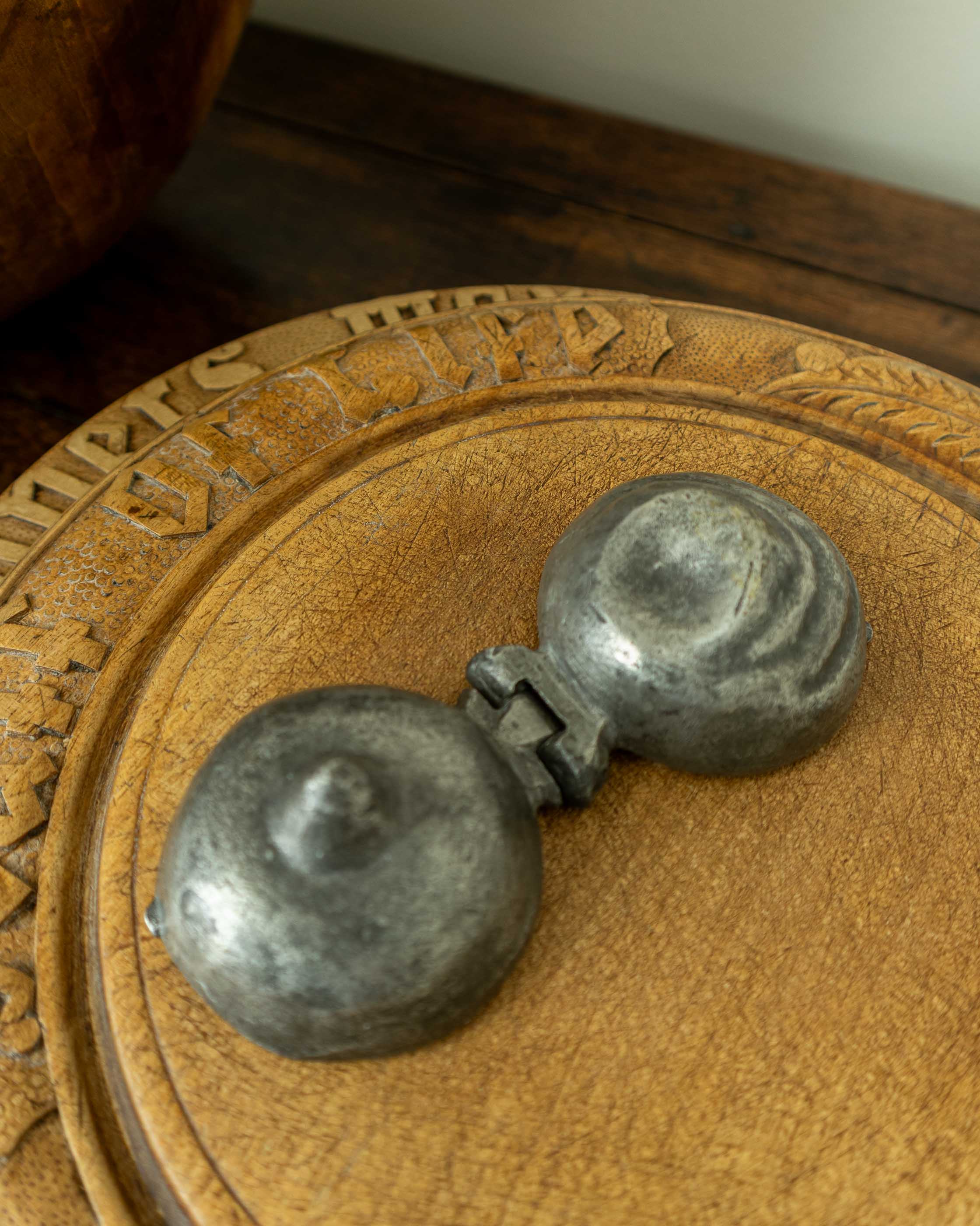 Decorative breadboard with a pewter mould on a wooden surface