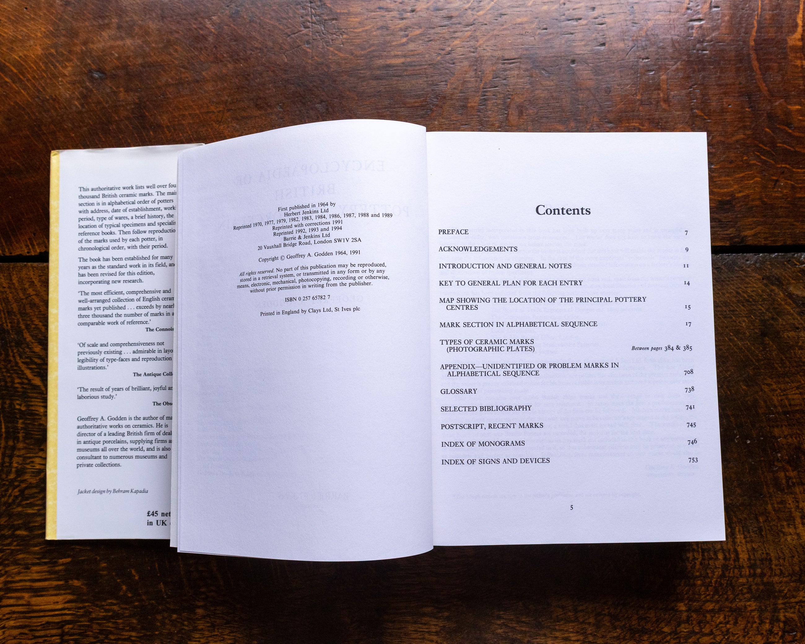 Open book on a wooden surface with a table of contents visible