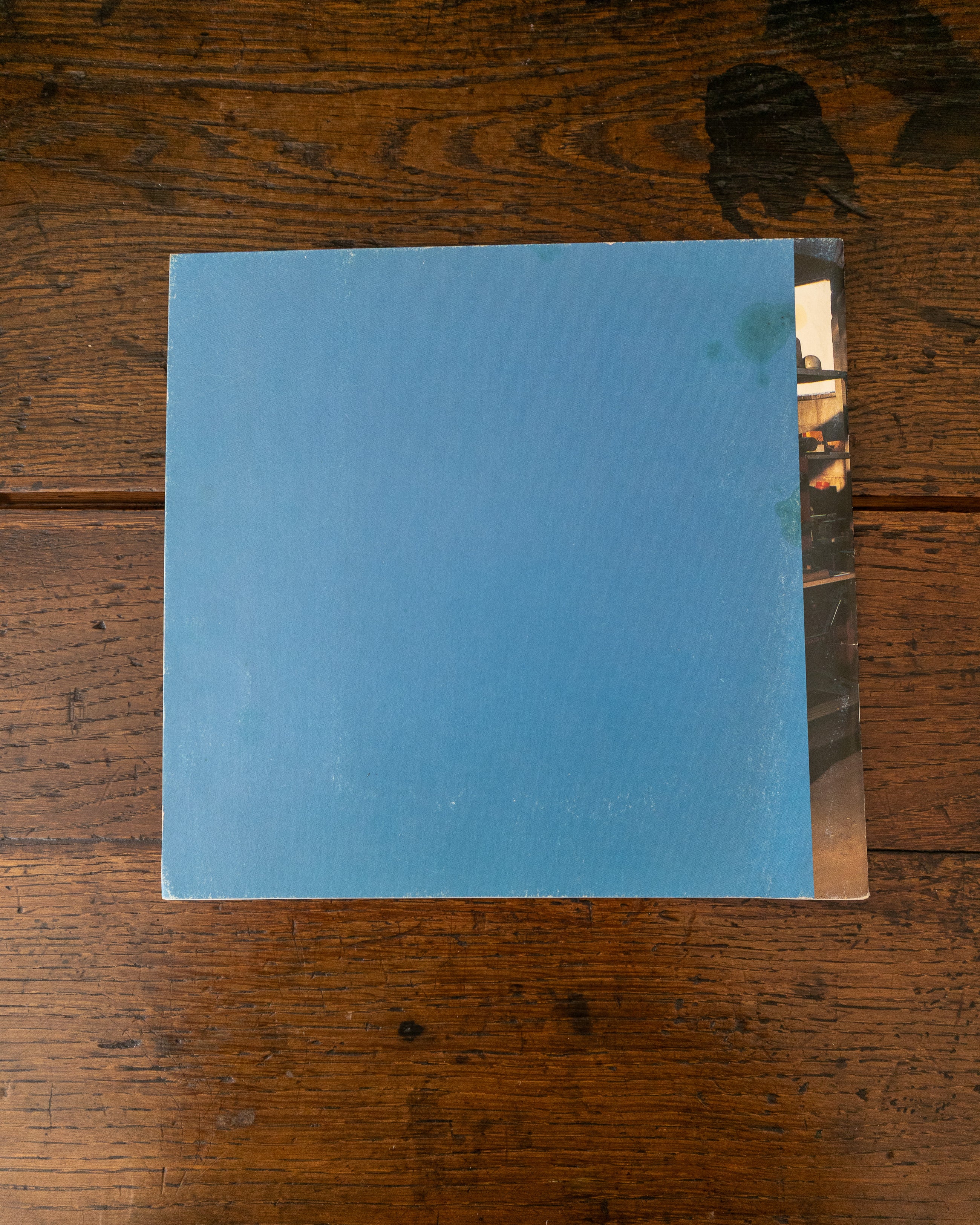 Back cover of blue book on a wooden surface.