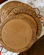 Wooden breadboards with engraved text on a patterned fabric background