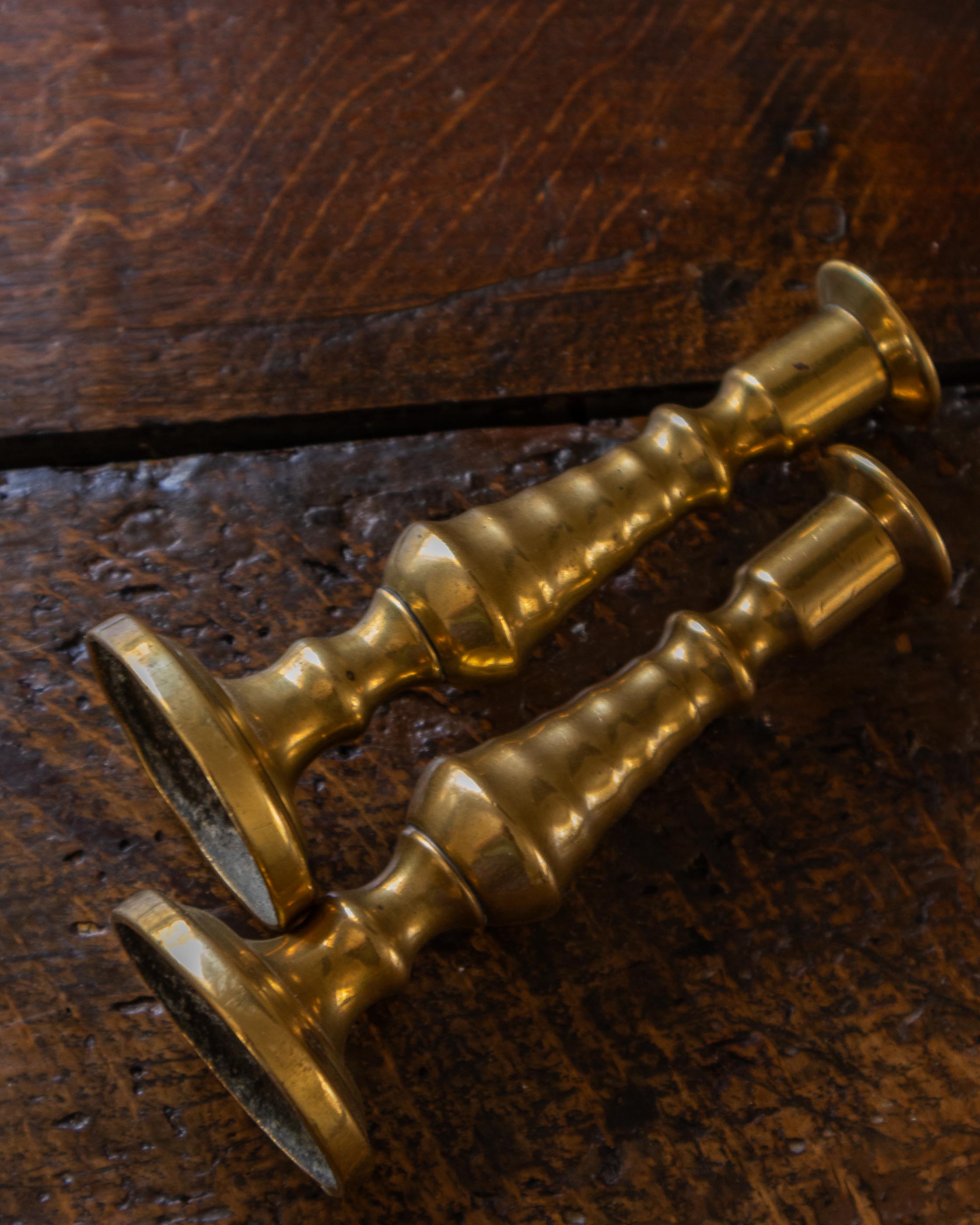Brass tapersticks on a wooden surface